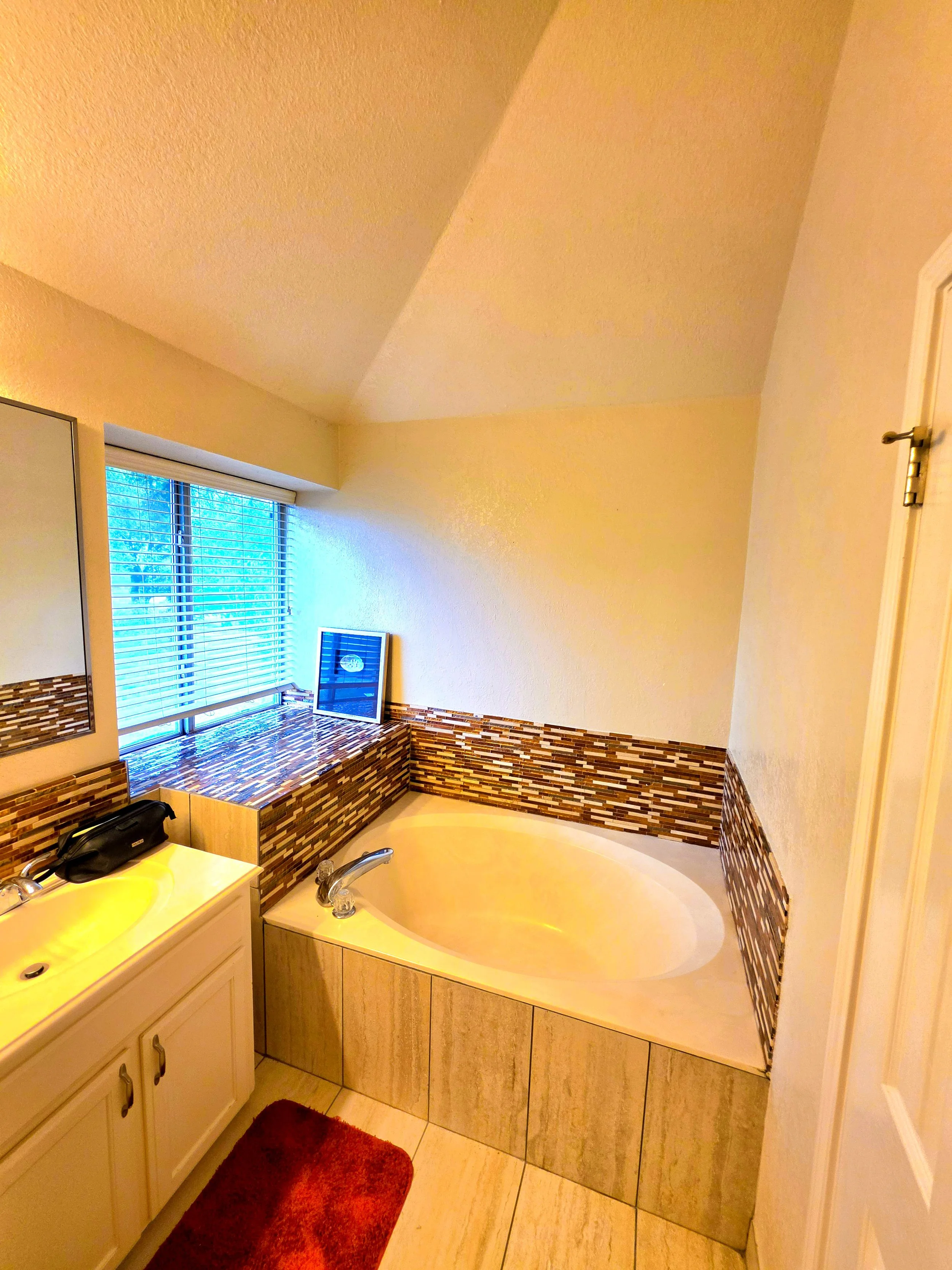 Featuring a spacious bathtub and plenty of storage in the bathroom.