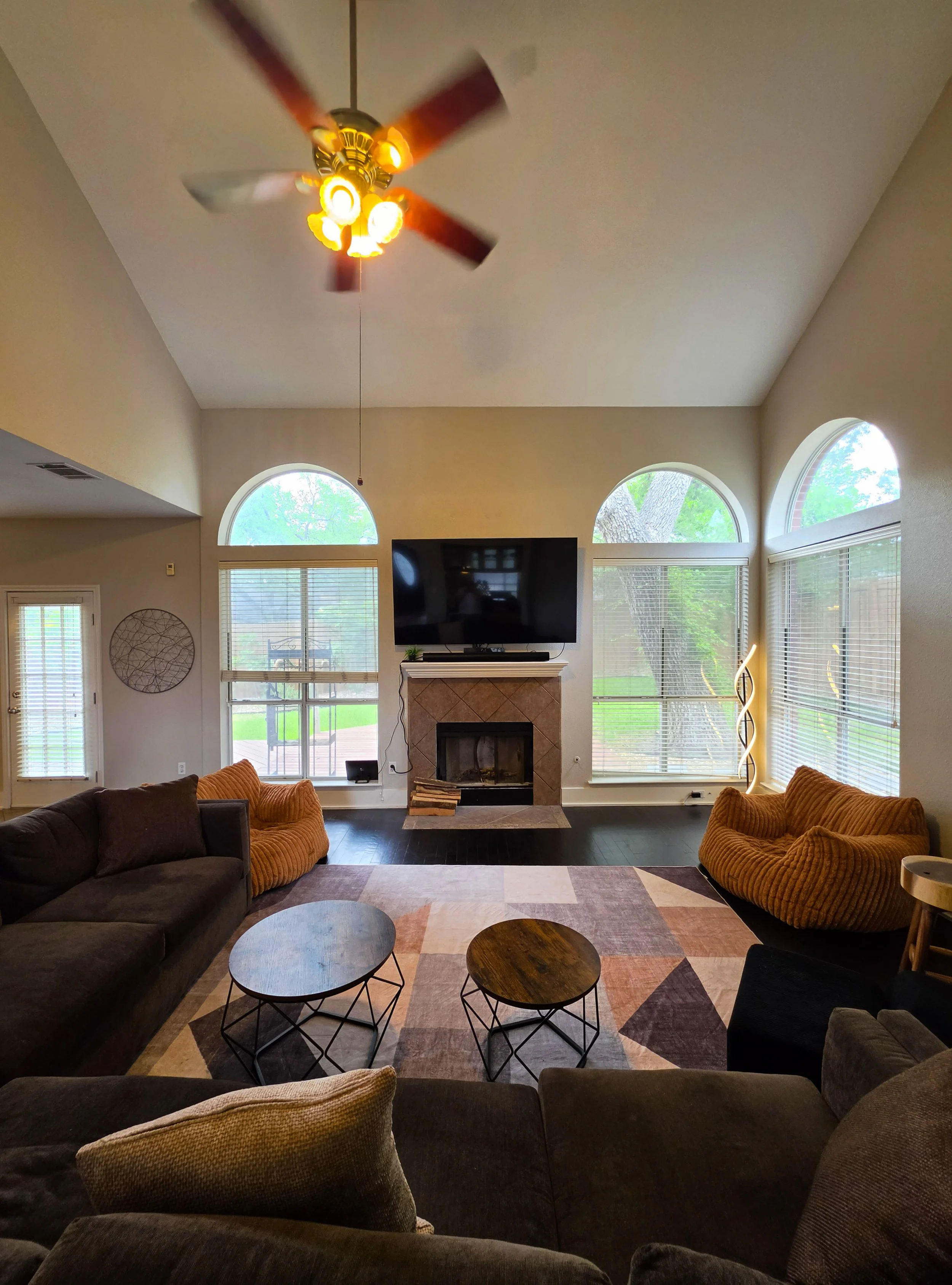 A large living room with a vaulted ceiling and fireplace at Fireside Sober Living in Austin, Texas. Offering alternative, non-AA, non-traditional and traditional program modalities.