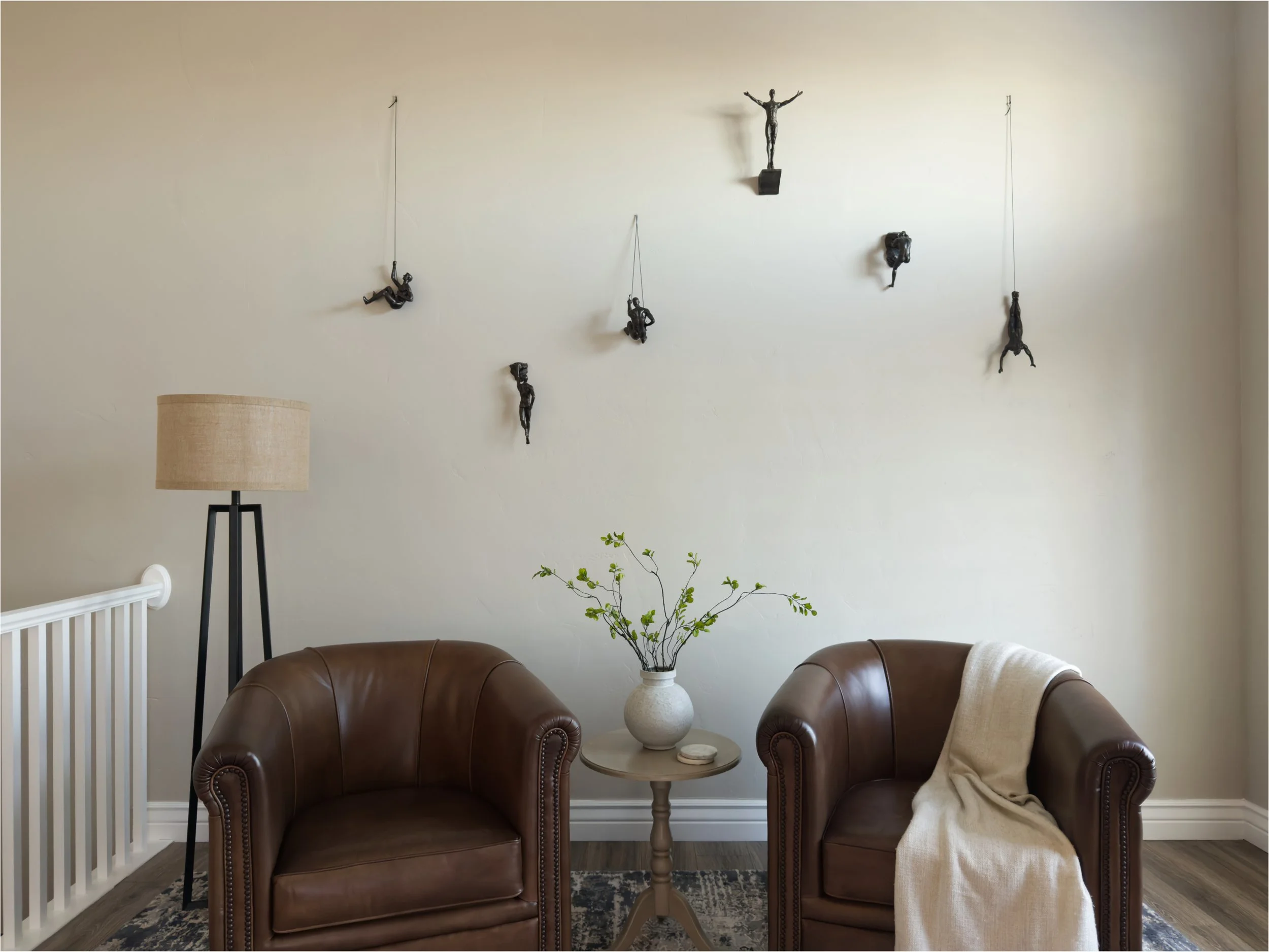 Custom decorated living room with two brown leather armchairs and modern art in Salt Lake City, UT. Reclamation Home offers affordable custom decorating  and design services in Davis County, Weber County, and Salt Lake County.