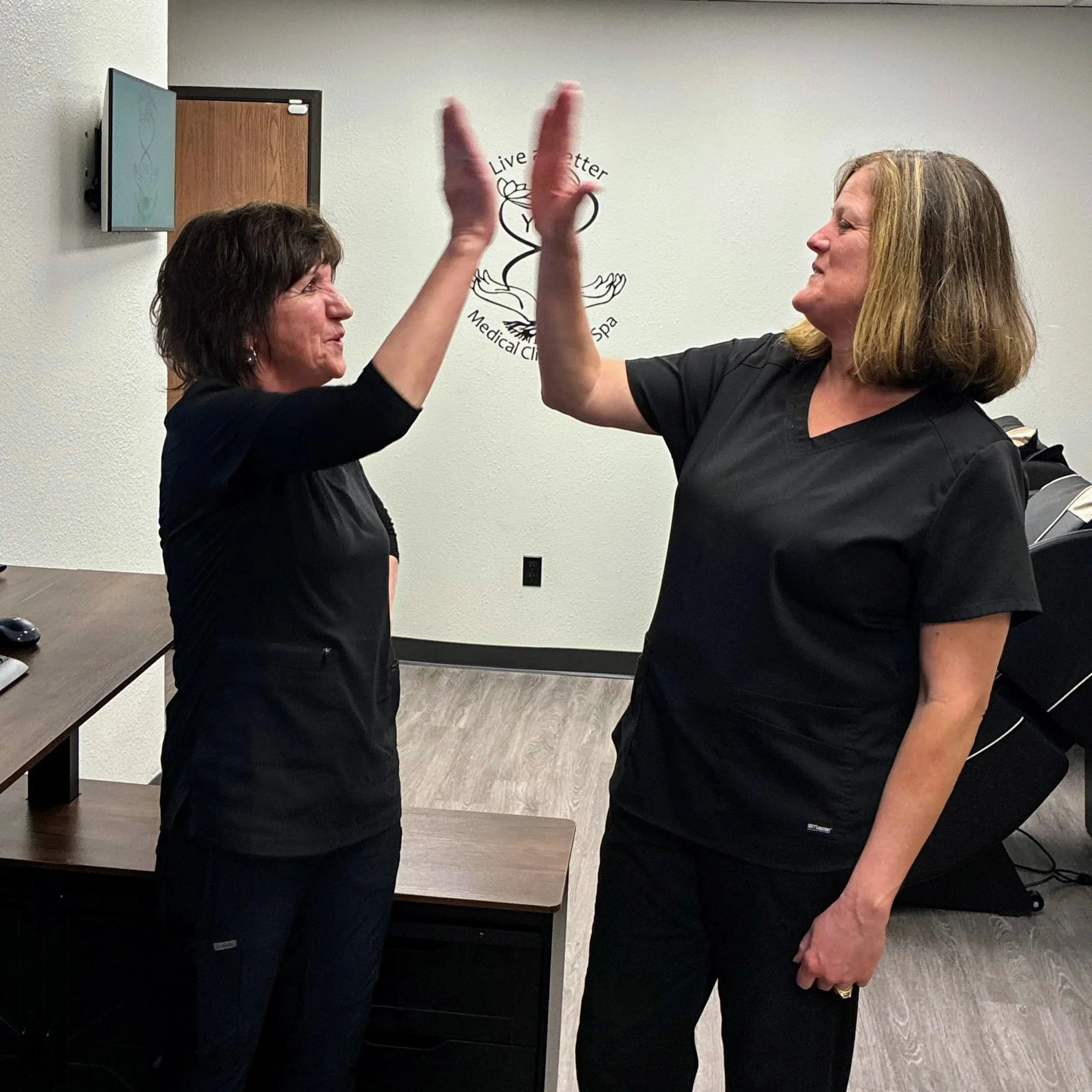 Bambi and Elizabeth giving each other a high five in the Live a Better You Clinic.