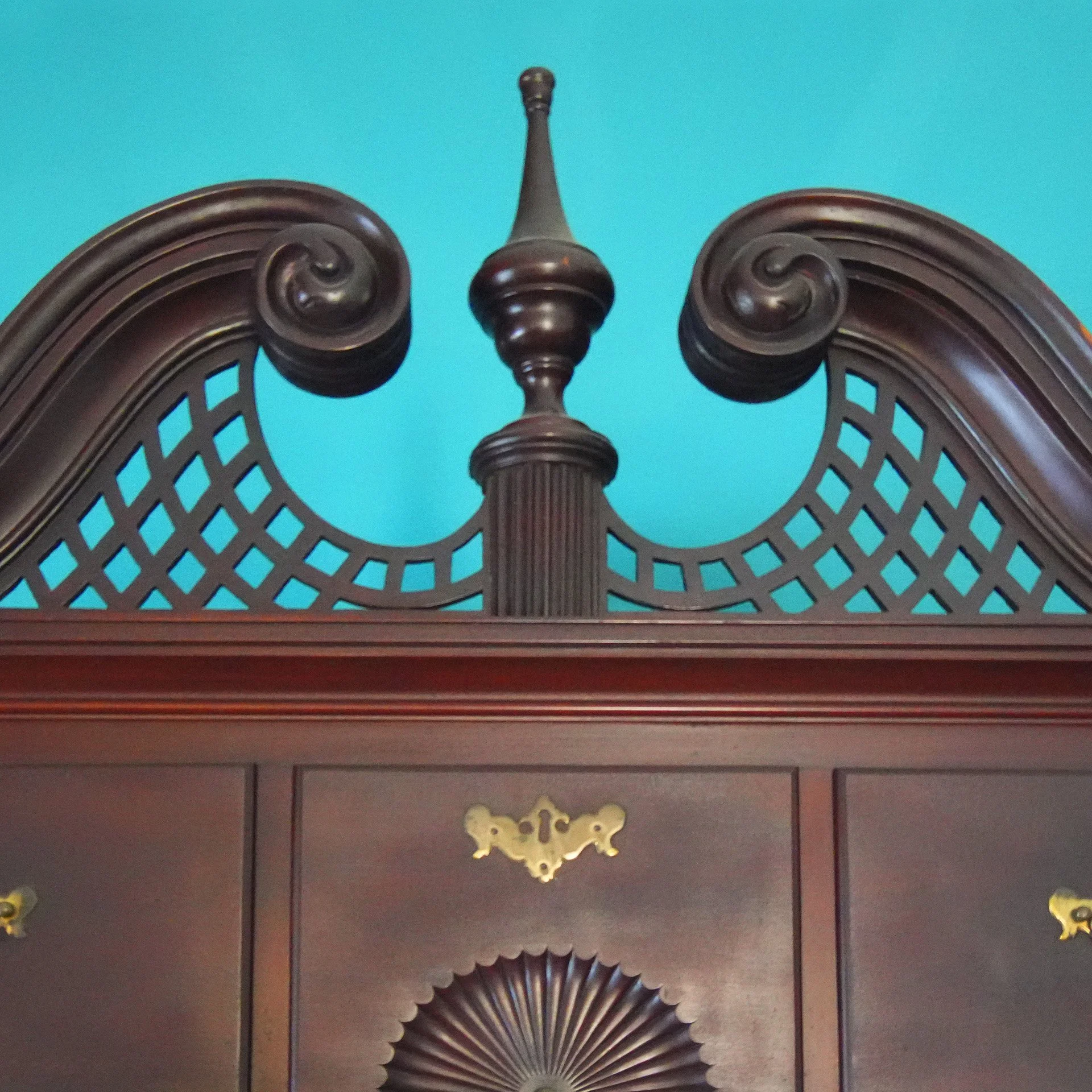 Decorative ceiling with wooden finial, lattice design, and butterfly-shaped ornaments on the wall.
