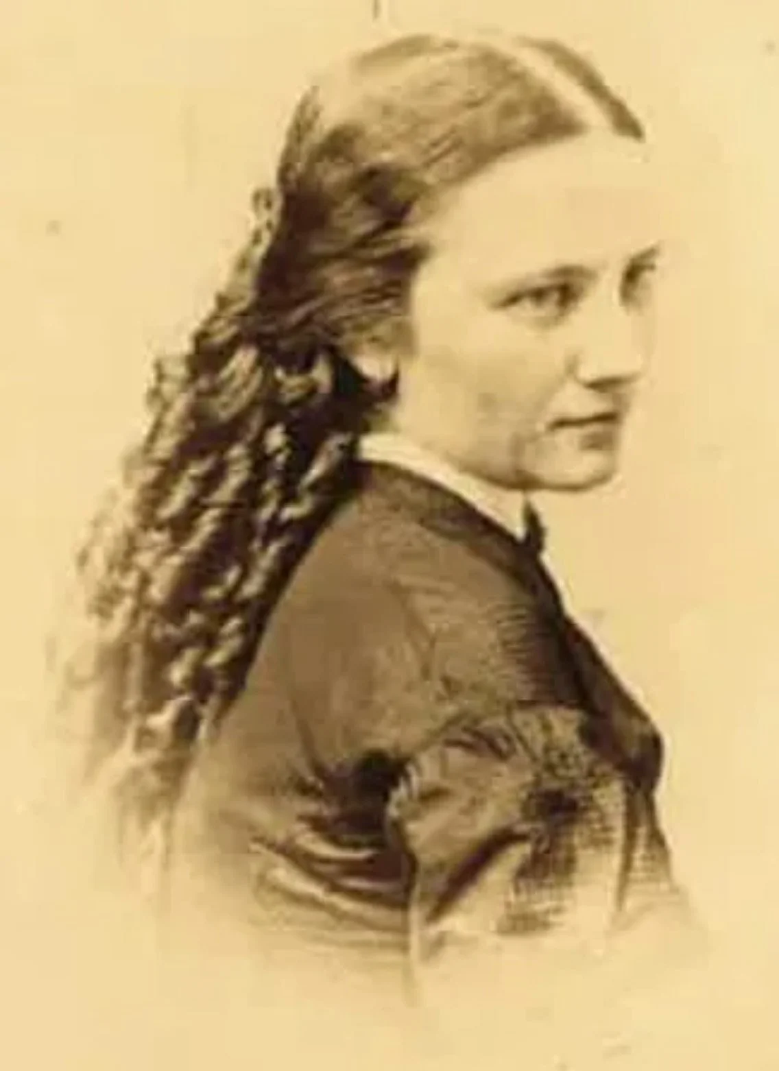 A sepia-toned portrait of a woman with braided hair, wearing a jacket, turned slightly to the side, looking into the distance.