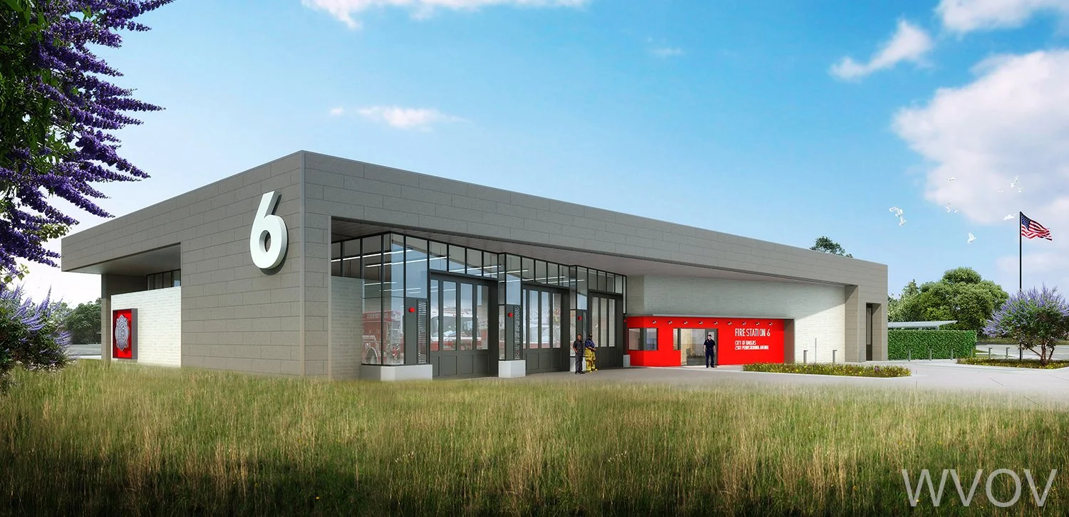 Modern fire station with a large number 6 on the facade, glass entrance doors, and a red sign indicating 'Fire Station 6'. There are people standing outside, a flag flying on a pole, and trees and grass surrounding the building.