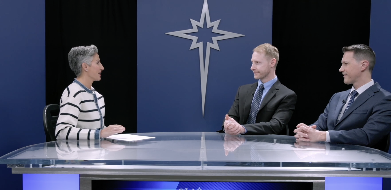 Woman interviewing two men at a desk