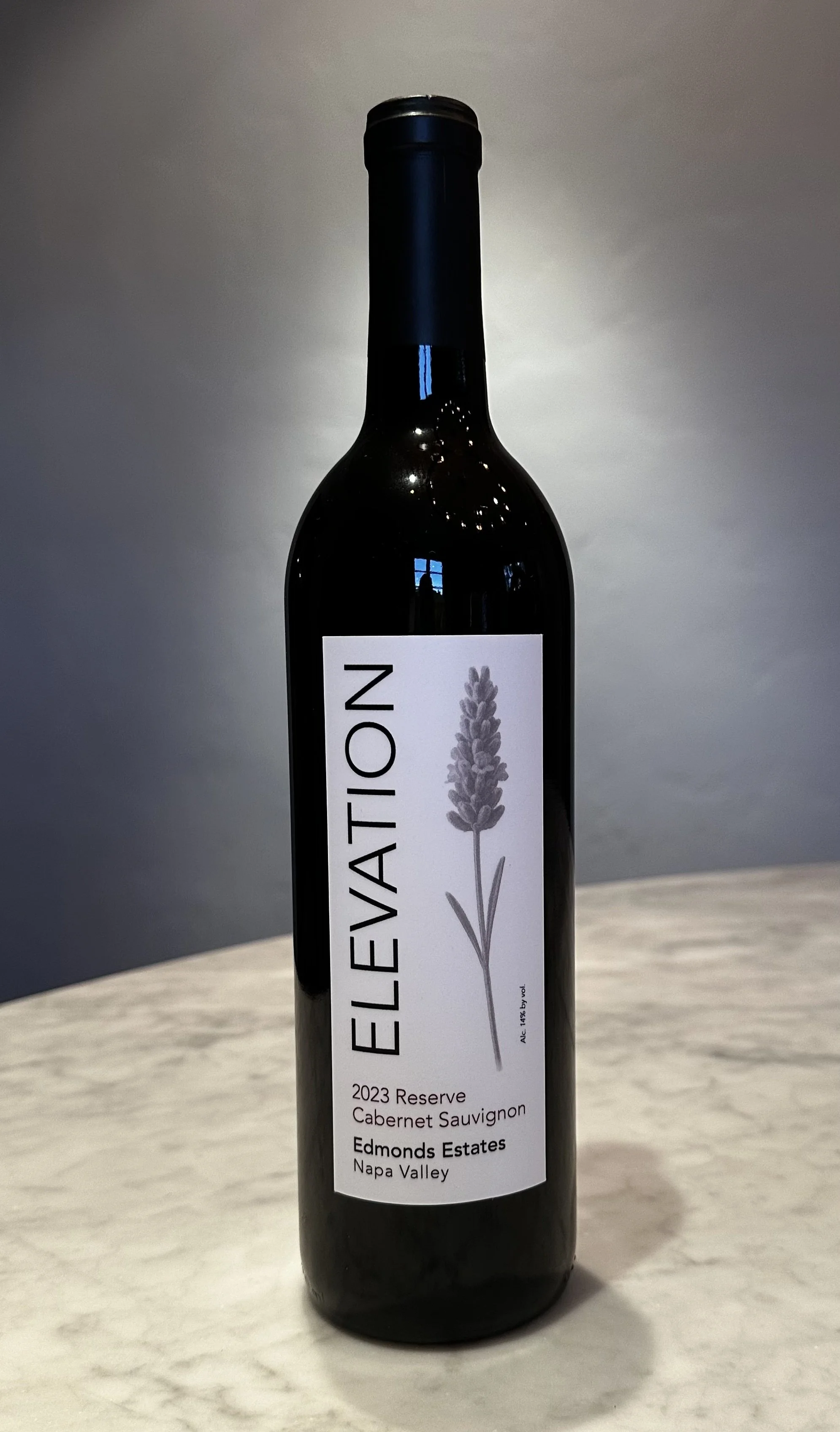 A bottle of Elevation 2023 Reserve Cabernet Sauvignon wine from Edmonds Estates in Napa Valley, with a white label featuring a lavender illustration.