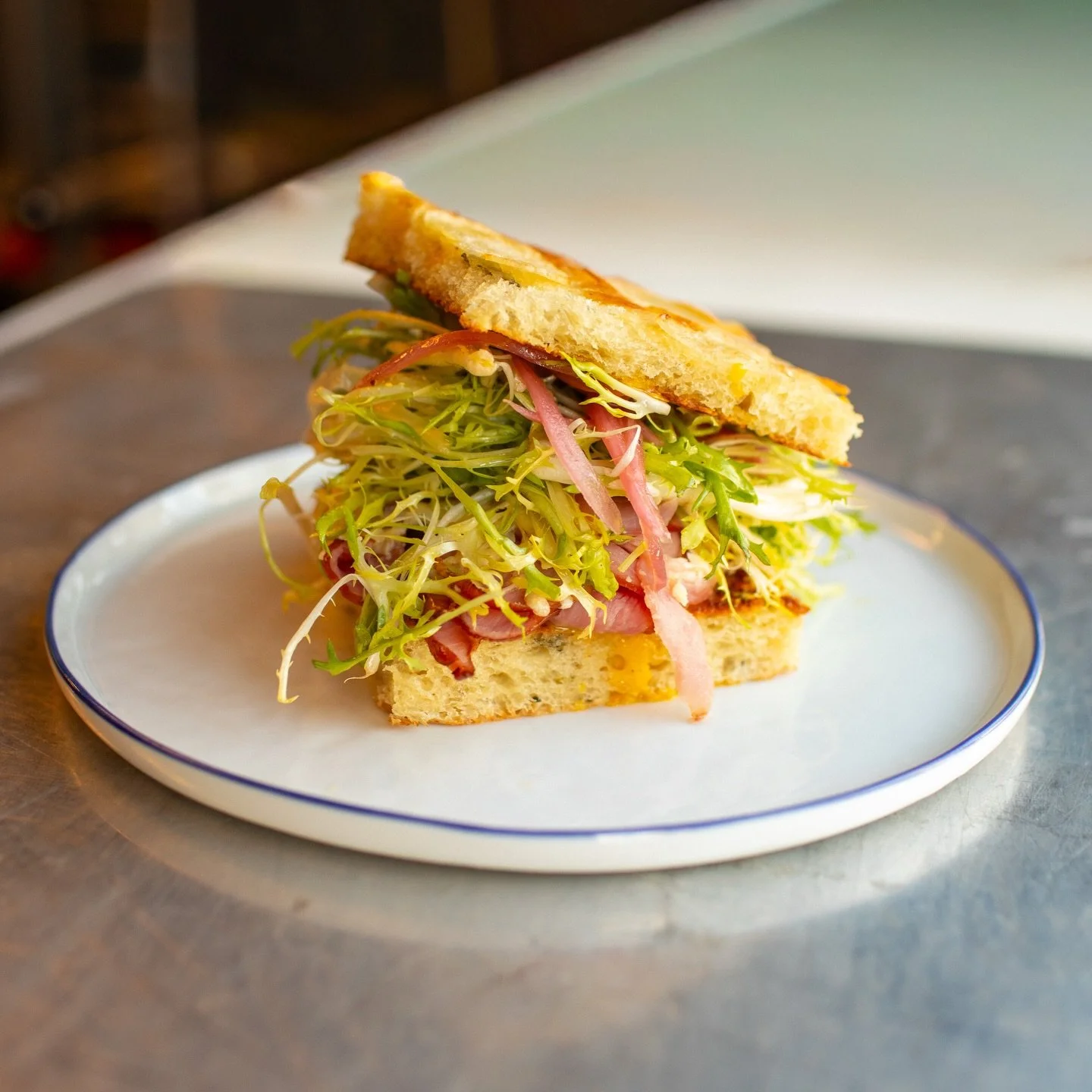 &ldquo;Lyonnaise&rdquo; Sando
Crispy Potato Focaccia, Slagel Farms Ham, Barber&rsquo;s Cheddar, Smoked Egg Yolk, Fris&eacute;e Salad