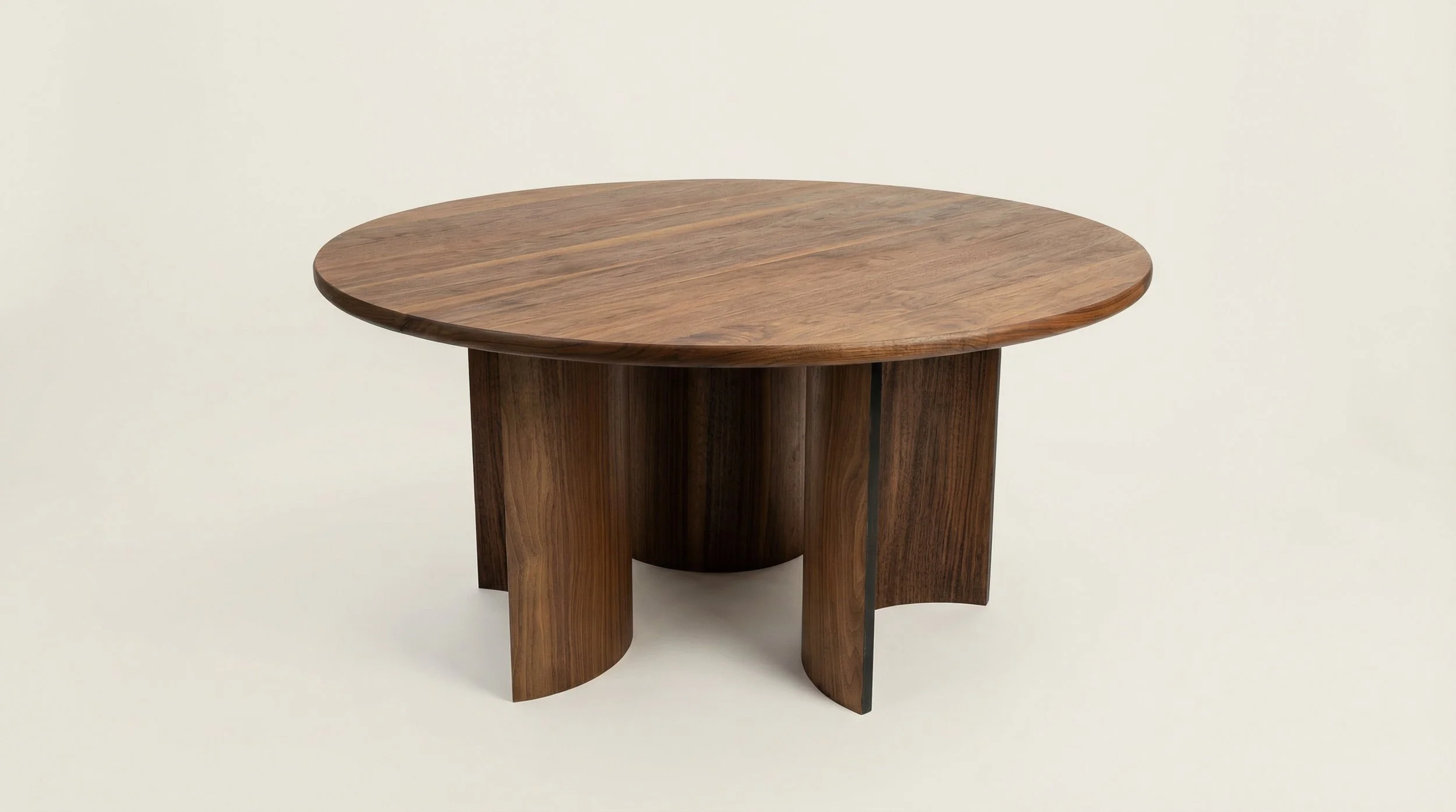 Round wooden table with a smooth top and curved legs against a plain light background.
