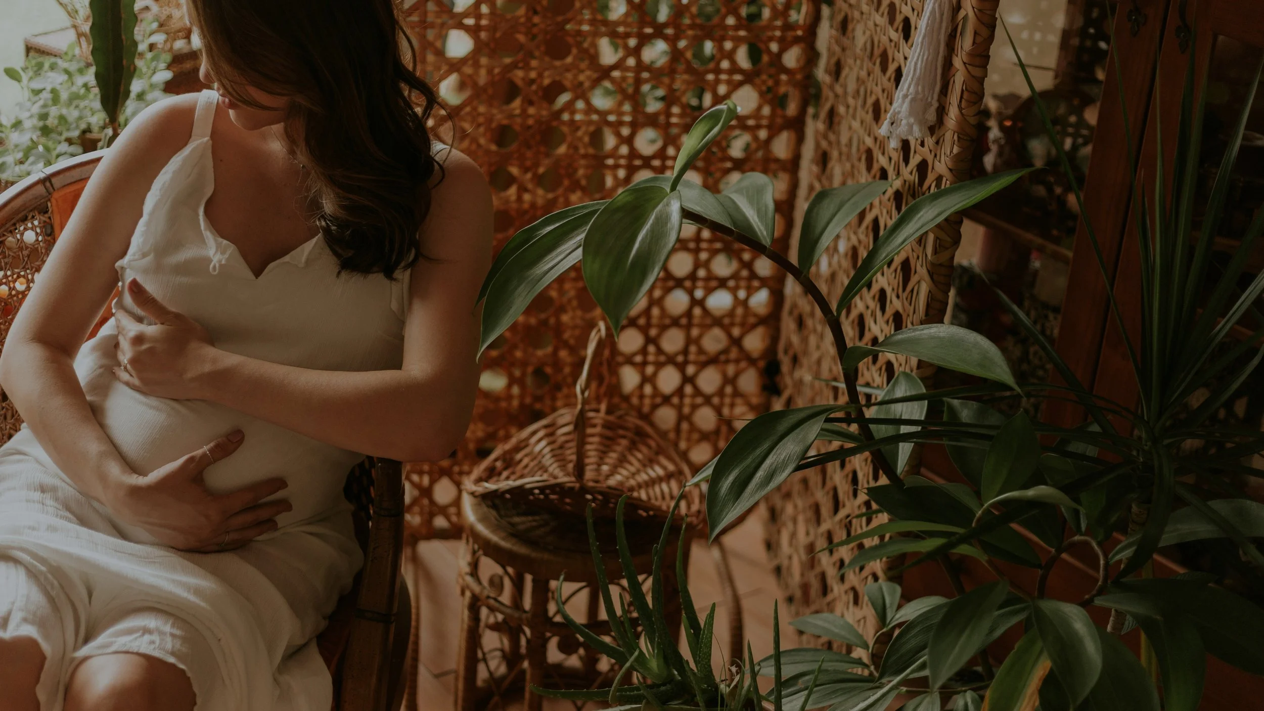 Courtney McMillian Midwife at Camina Wellness and Midwifery in Boca Raton, providing holistic home birth planning, postpartum care, and trauma-informed gyn wellness in South Florida. A picture of a mother holding her pregnant belly.