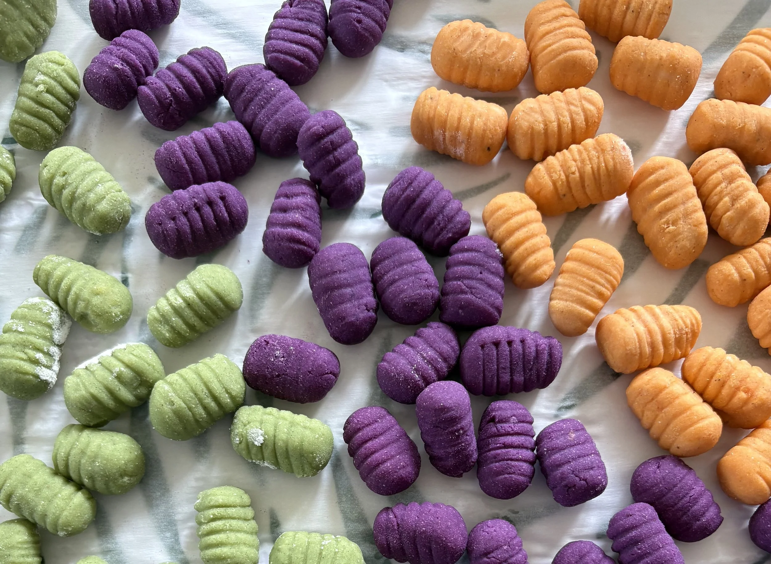 Colorful orange, spinach, and purple sweet potato Patatina gnocchi.