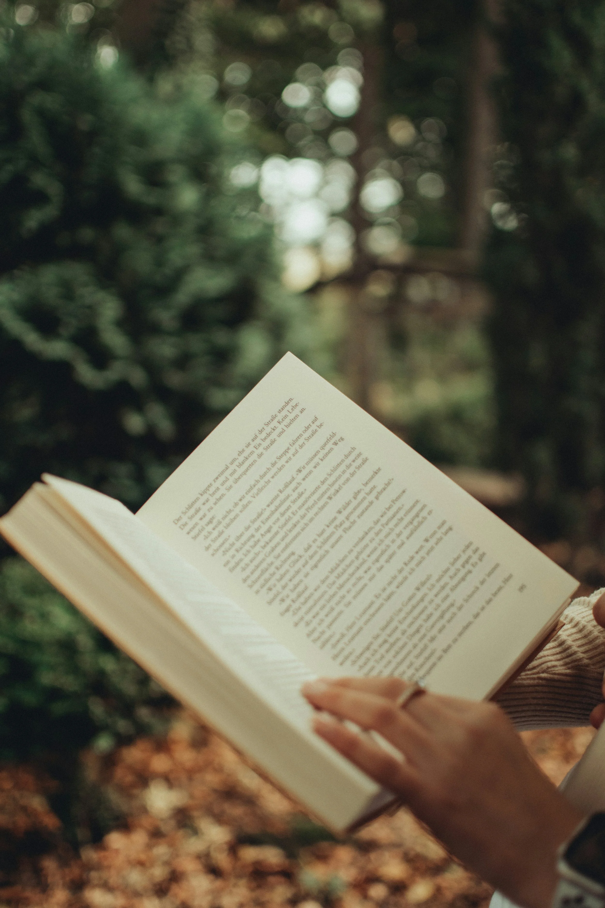 A woman reading a book in the forest