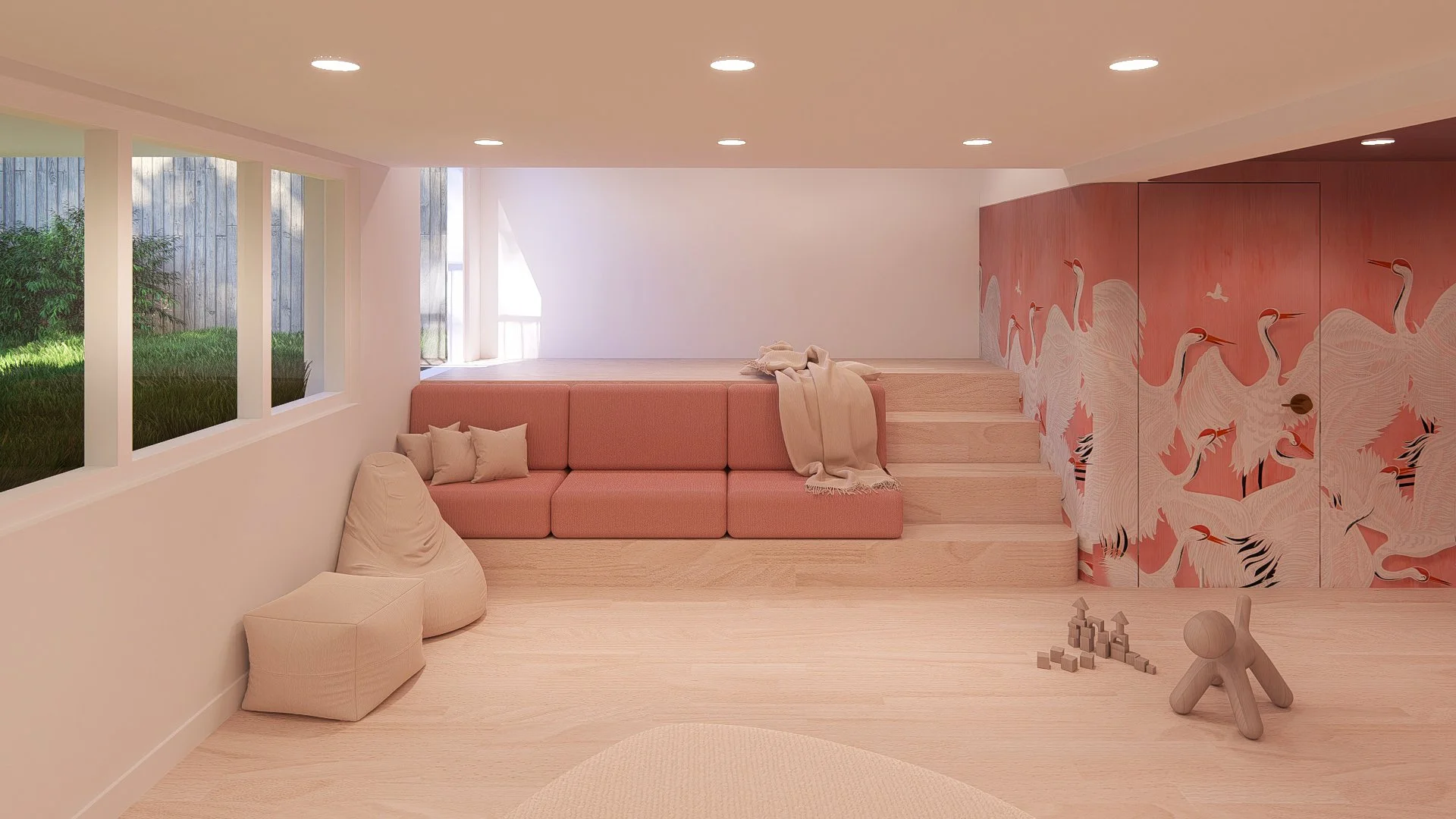 A cozy, modern playroom with pink and beige tones. Features a pink sectional sofa with beige pillows, bean bag chair, and blanket on stairs. The wall has a crane mural on a pink background. Wooden toys and blocks on the light wood floor, large window
