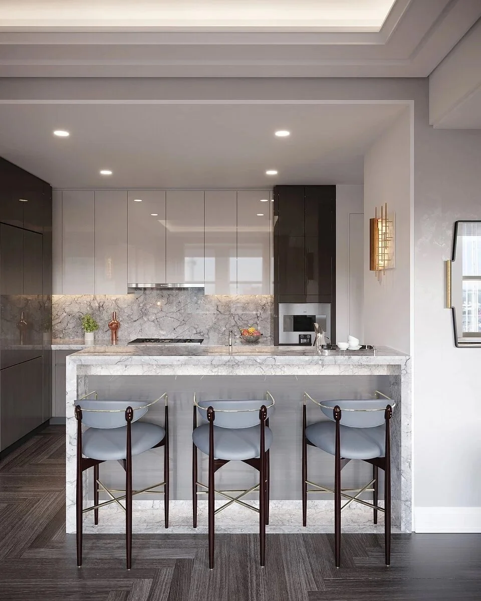 Modern kitchen with white and dark cabinetry, marble countertops, and a marble island with three barstools, hardwood floors, and minimalistic decor.