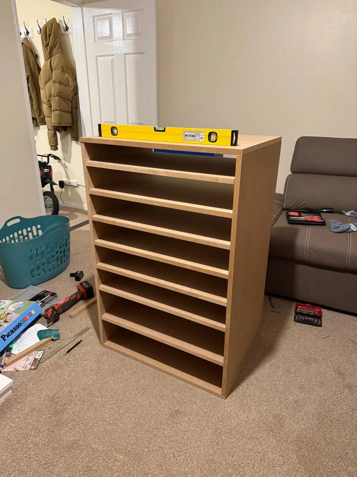 A wooden bookshelf with multiple shelves stands in a room, having completed a furniture assembly or home improvement project.