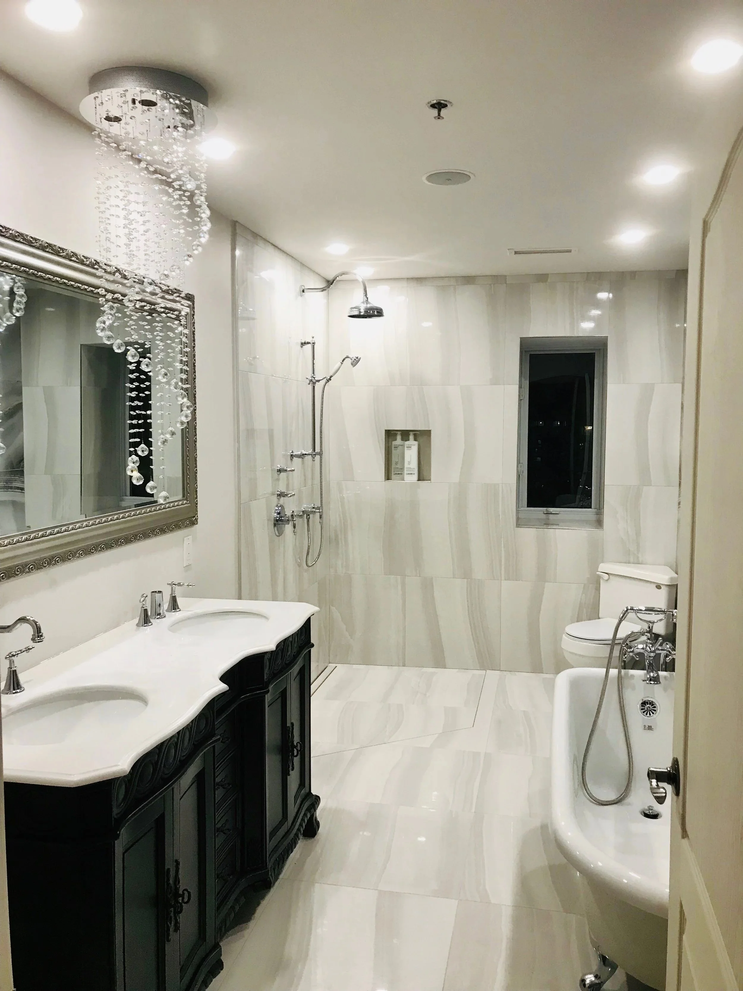Full bathroom renovation in downtown Montreal, showcasing designer-picked large tiles and sleek, modern fixtures for a striking result