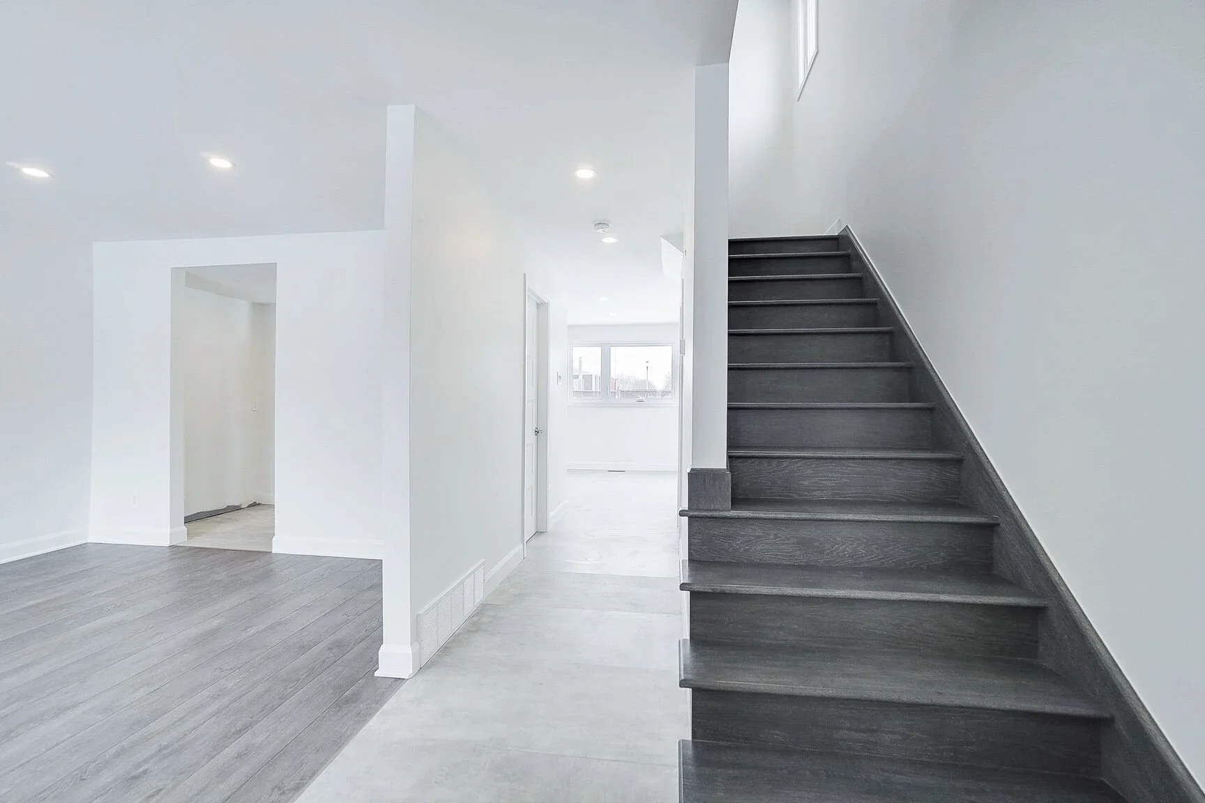 Complete renovation of the entrance, living room and staircase leading to the second floor in a semi-detached house in Pierrefonds, West Island Montreal. This project showcases a thoughtful selection of premium materials and bright, modern paint colo