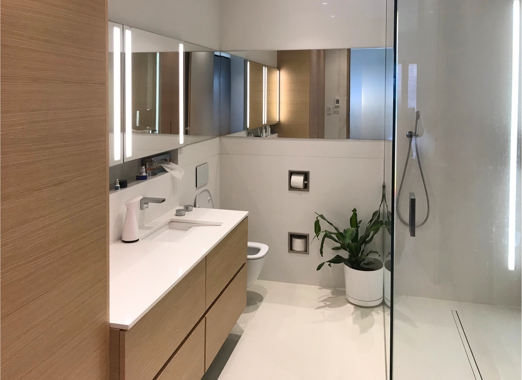Montreal Residence — Bathroom Renovation | Large-format light-toned ceramic paired with custom-built cabinetry shaping a clean, contemporary bathroom in this downtown Montreal home.