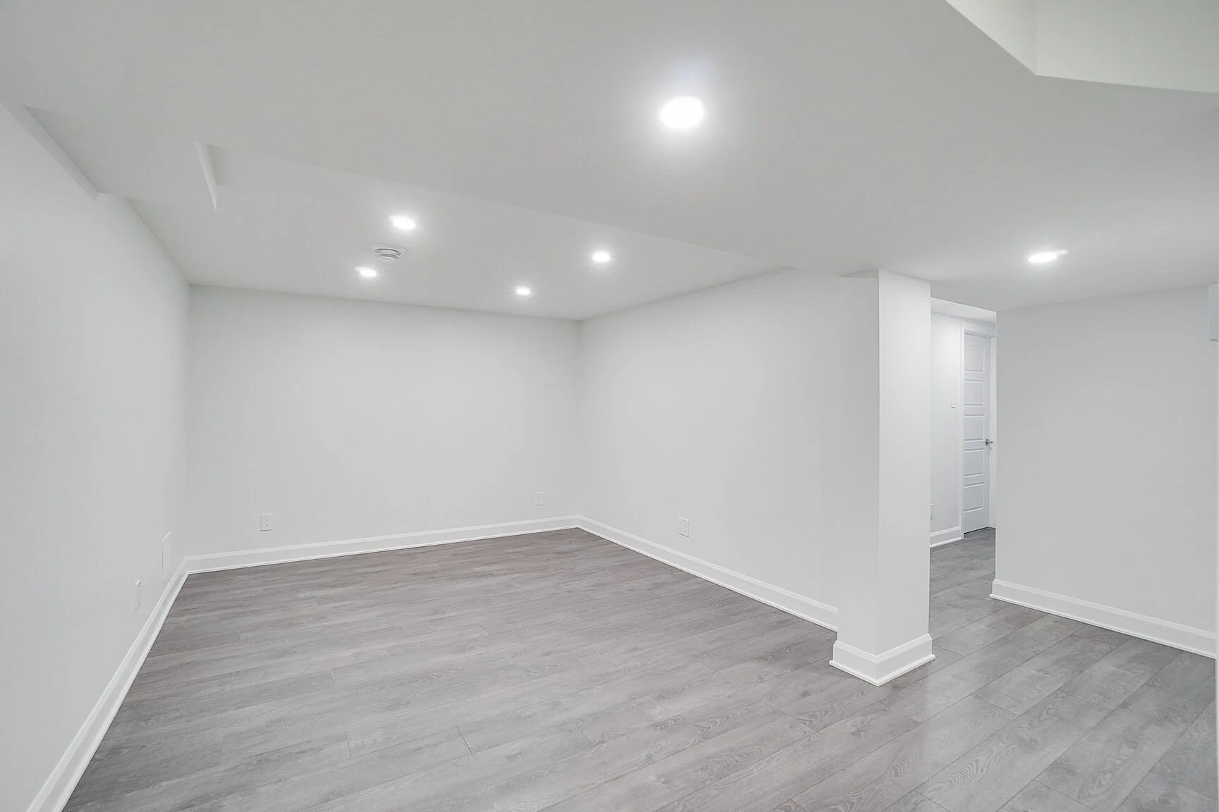 Basement renovation in Pierrefonds, West Island Montreal, transforming a basement with limited natural light into a bright and functional living space. The project includes a cozy living room, a dedicated work-from-home office and an adjacent bathroo