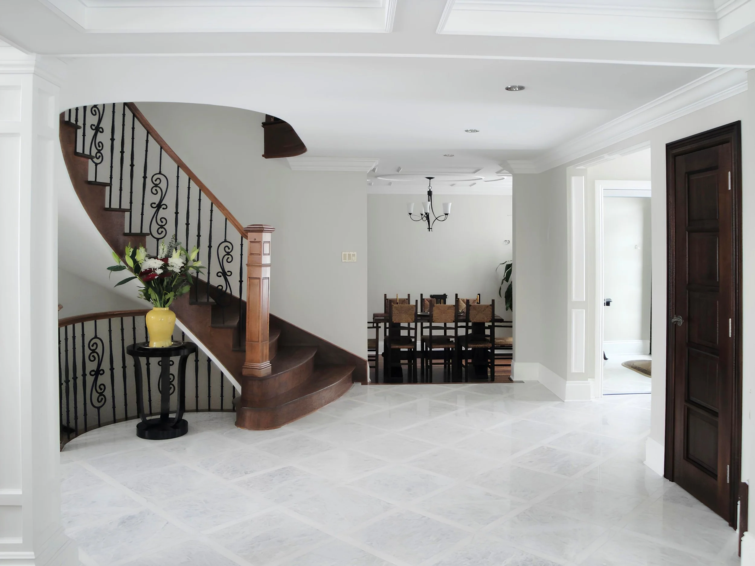 White marble flooring and custom wooden staircase in a renovated Beaconsfield residence