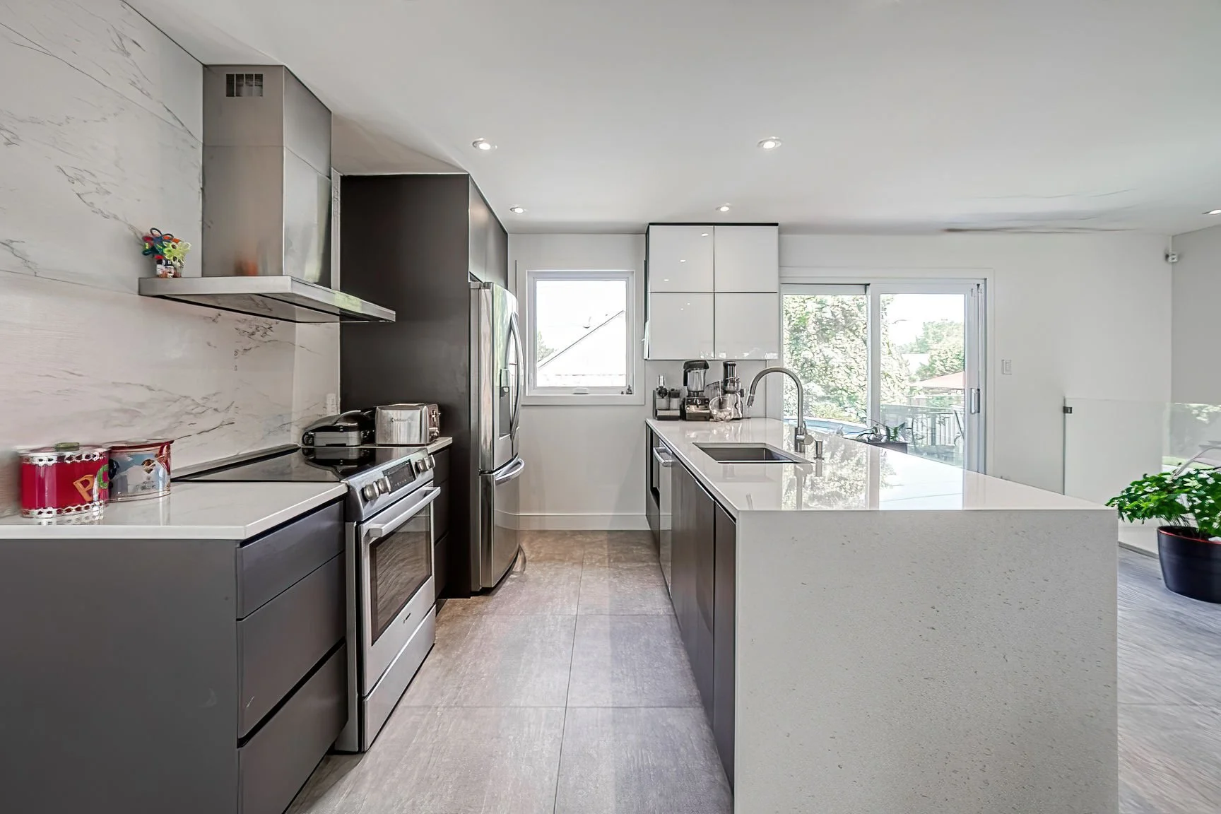 Modern kitchen renovation featuring custom cabinetry, stone countertop and minimalist design