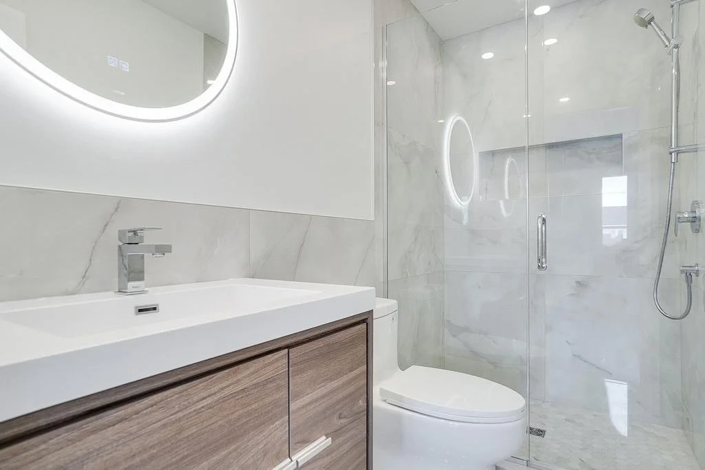 Master bedroom transformation in a semi-detached Kirkland home, West Island Montreal, to create an in-suite bathroom with beautiful large white ceramic tiles for a bright, spacious, and sleek design