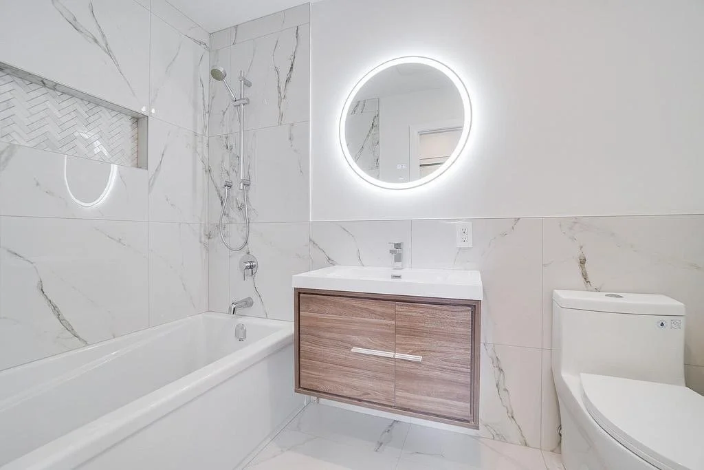 Complete remodel of the main bathroom on the second floor of a semi-detached home in Kirkland, West Island Montreal, featuring beautifully selected large white ceramic tiles for a bright, spacious, and elegant design