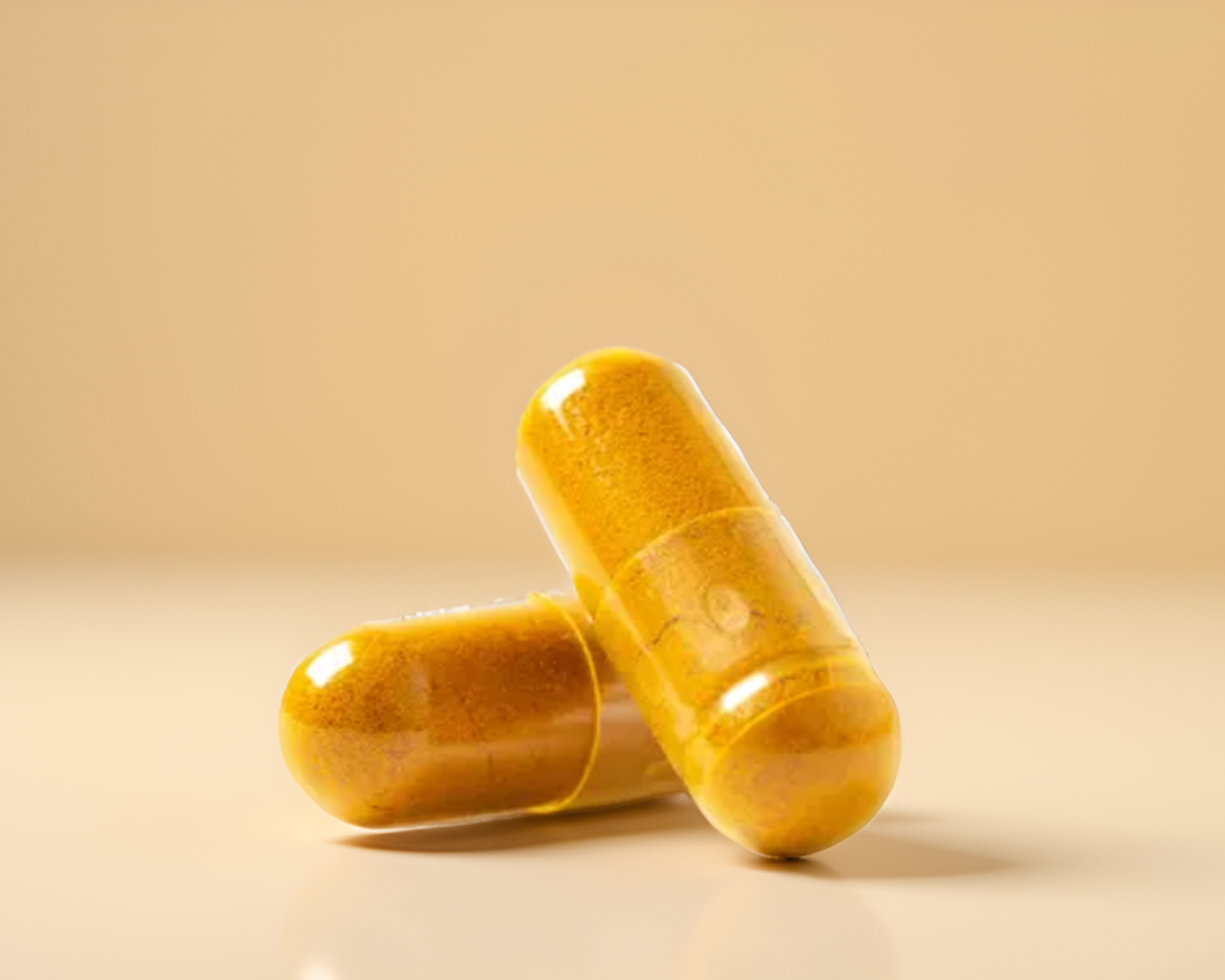 Two yellow and brown capsules placed on a neutral background.