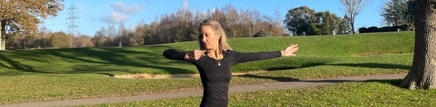 Hellen Barlow, Yoga for golfers coach, stretching and rotating outdoors in a sunny golf club