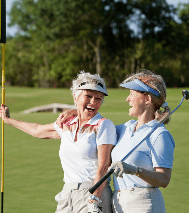 Two lady golfers very happy at the grounds of a golf club