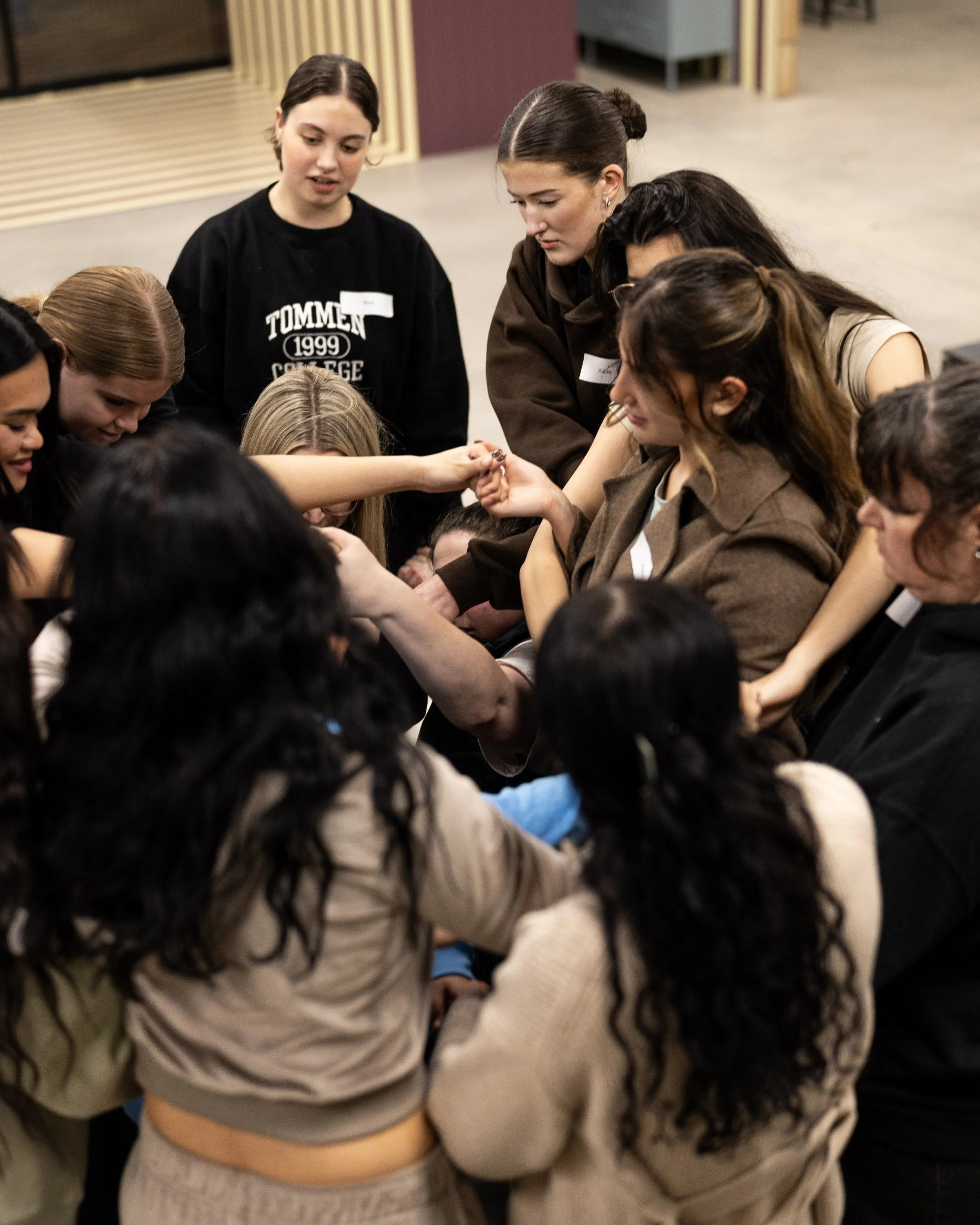 A team of women gathered closely together, engaging in a Field9 team building experience in Adelaide.