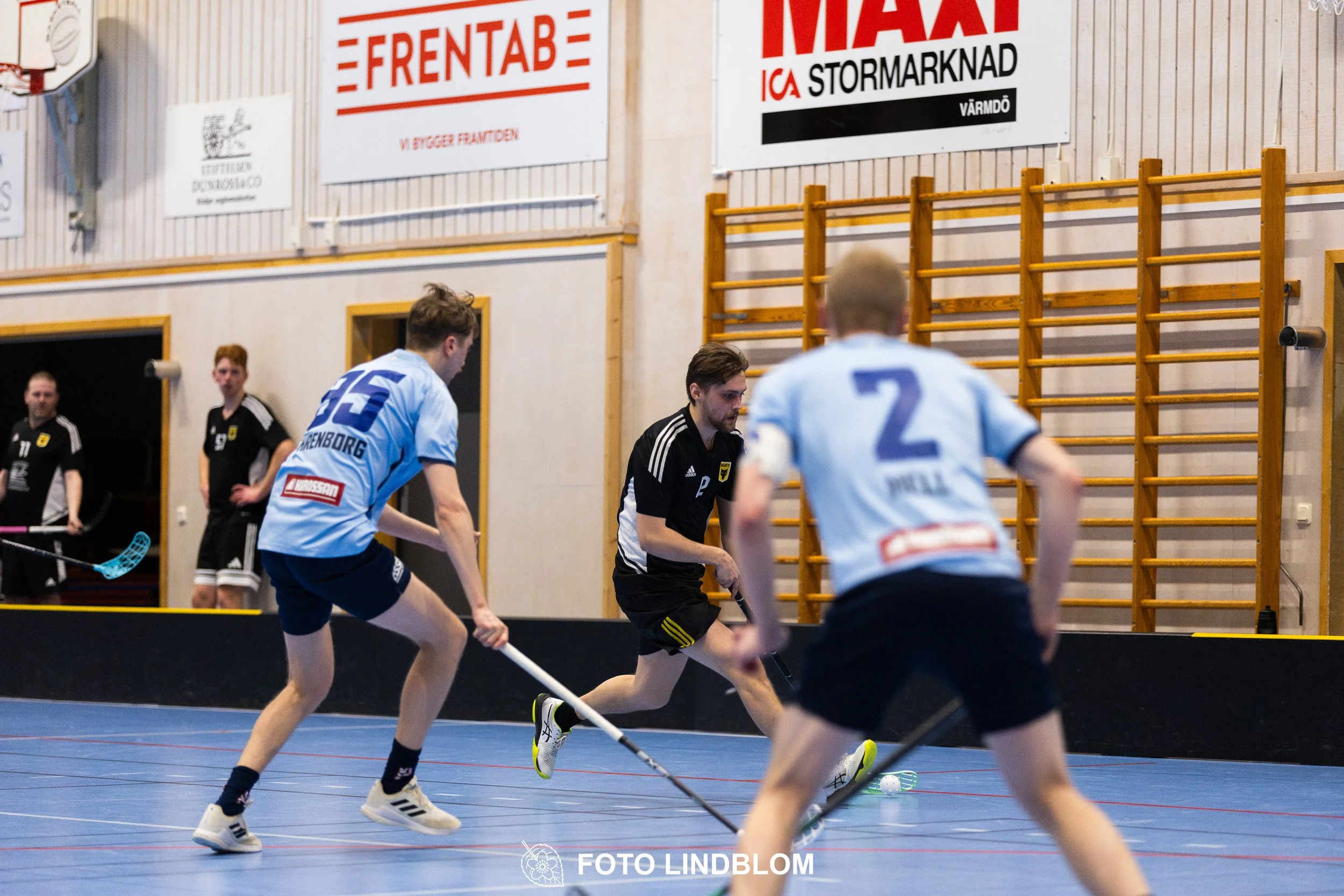 A picture of men playing floorball in Ingarö IF and Älvsjö AIK IBF team gear