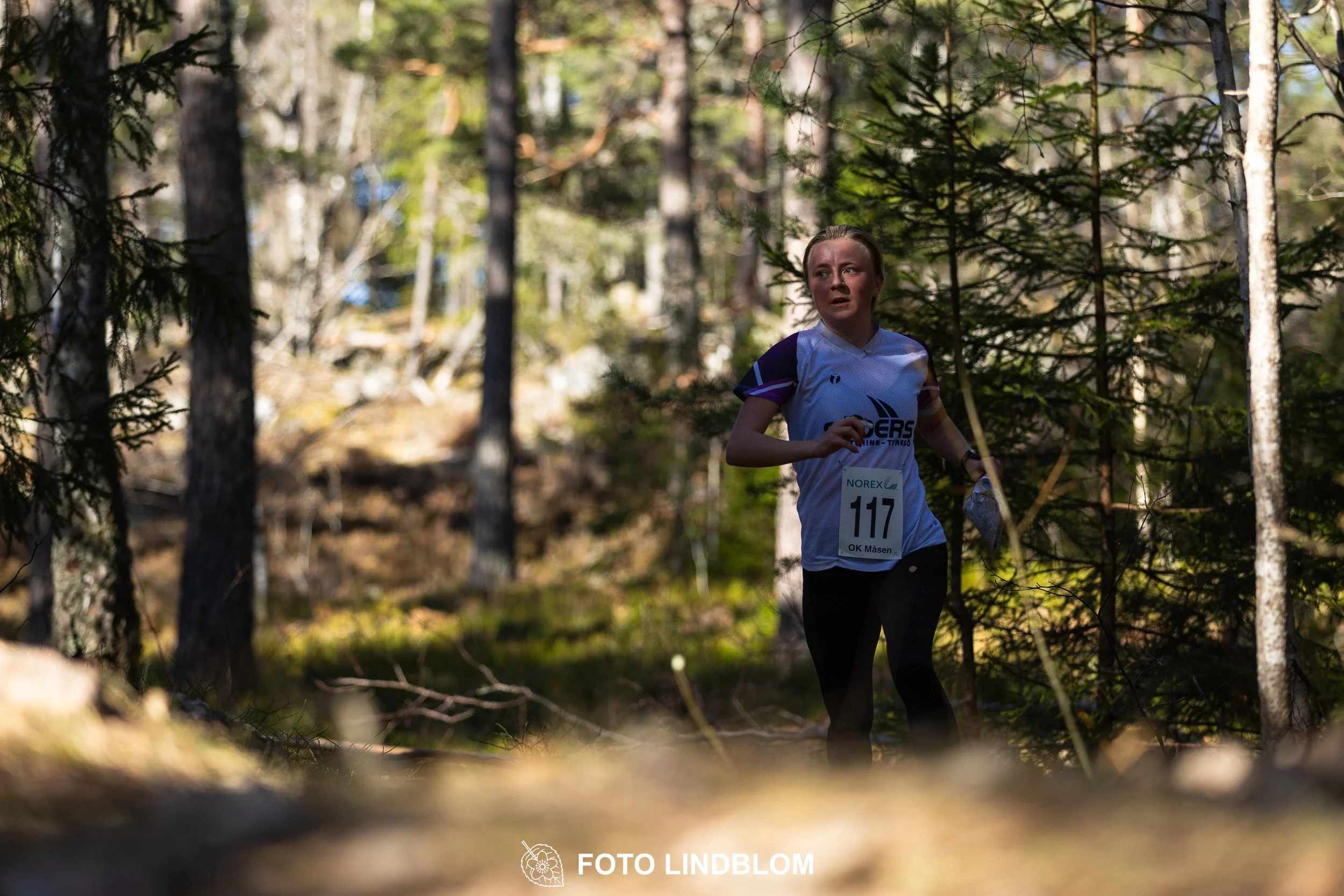 Forest relay orienteering at Måsenstafetten 2026, with teams competing in an endurance event, documented by Foto Lindblom.