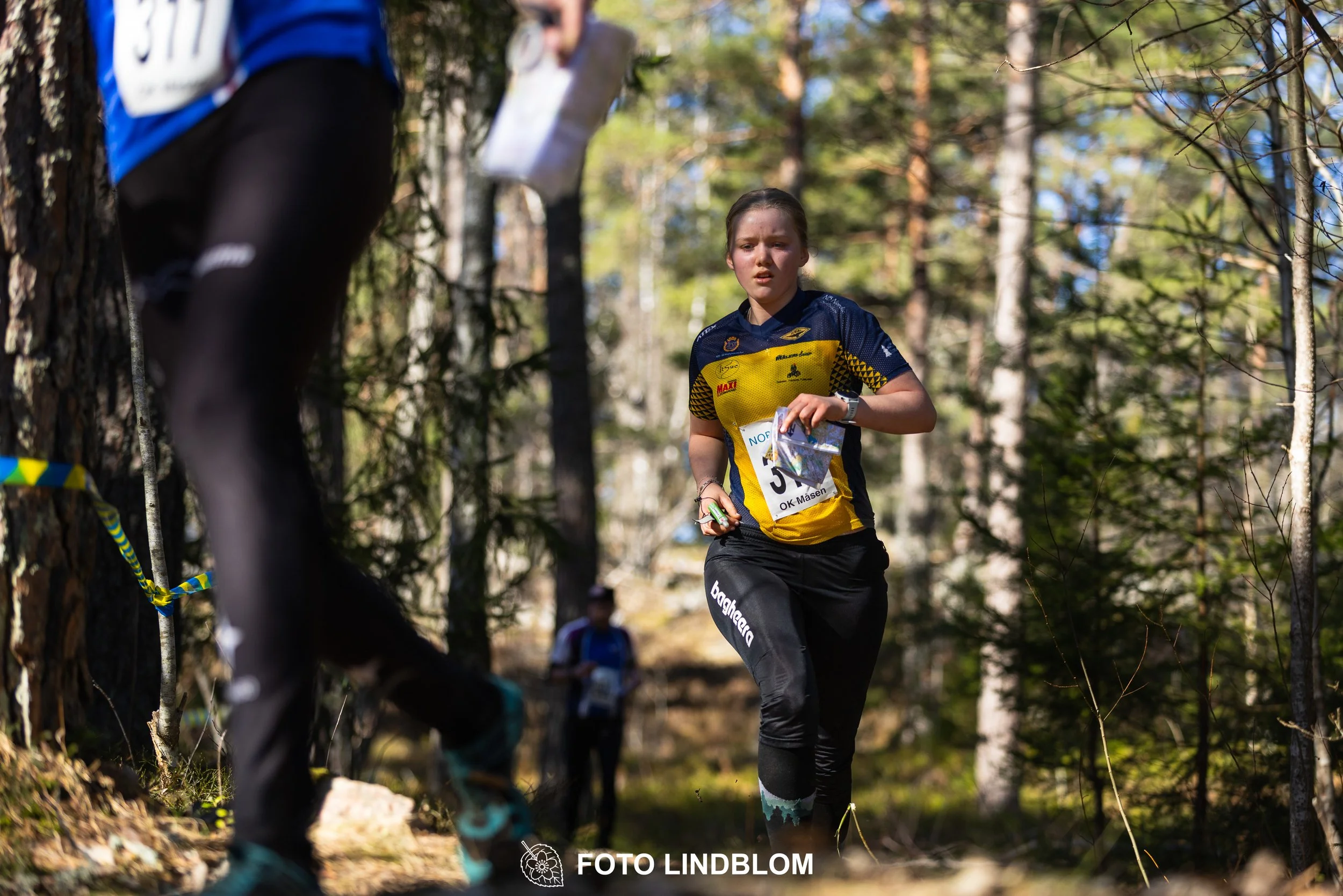 A relay-stage photo from Måsenstafetten 2026, featuring team-based orienteering competition, taken by Foto Lindblom.