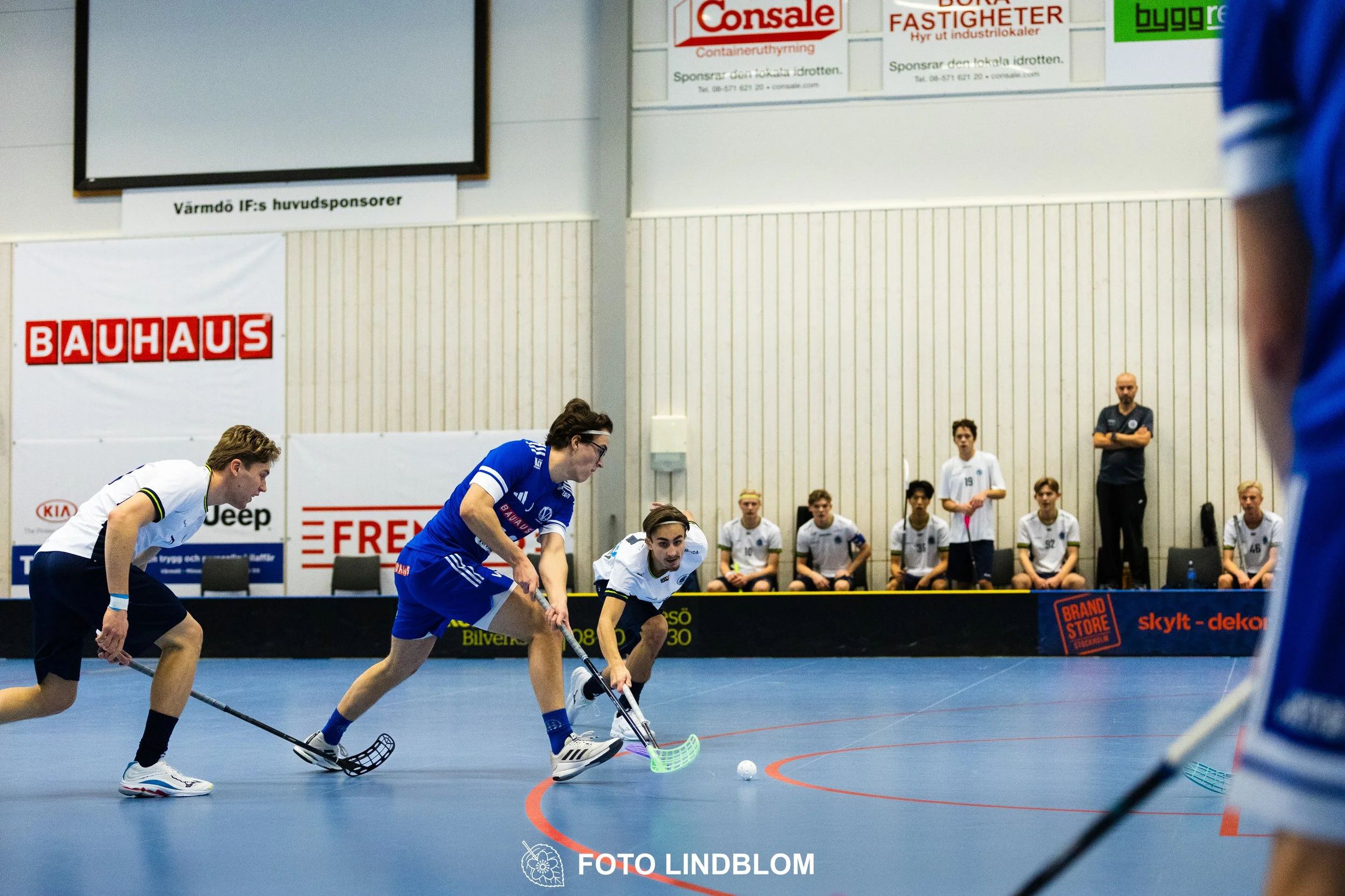 Images of people playing floorball wearing Värmdö IF and FBC Sollentuna team gear. 