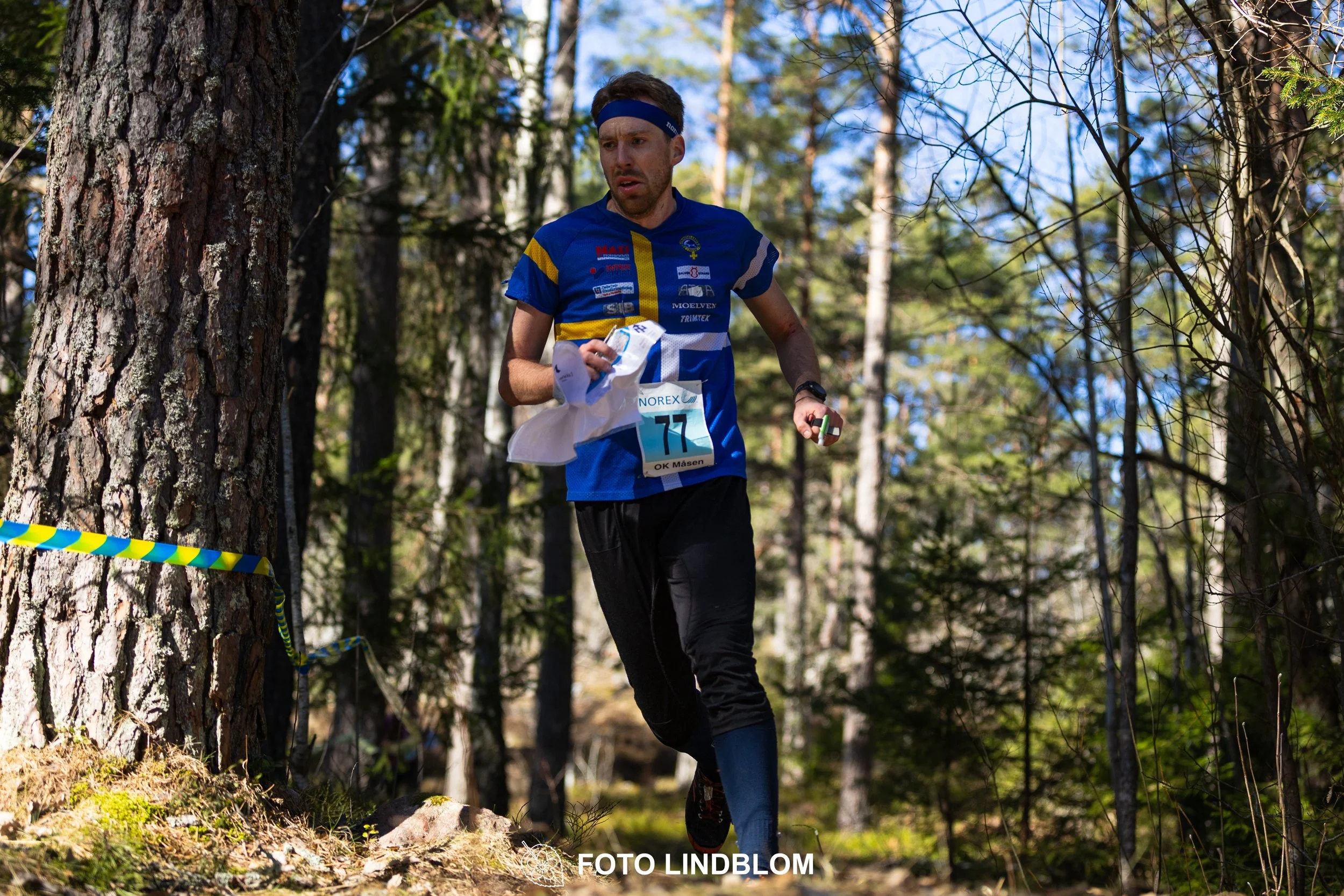 Orienteering relay race at Måsenstafetten 2026, featuring club teams navigating with map and compass, captured by Foto Lindblom.