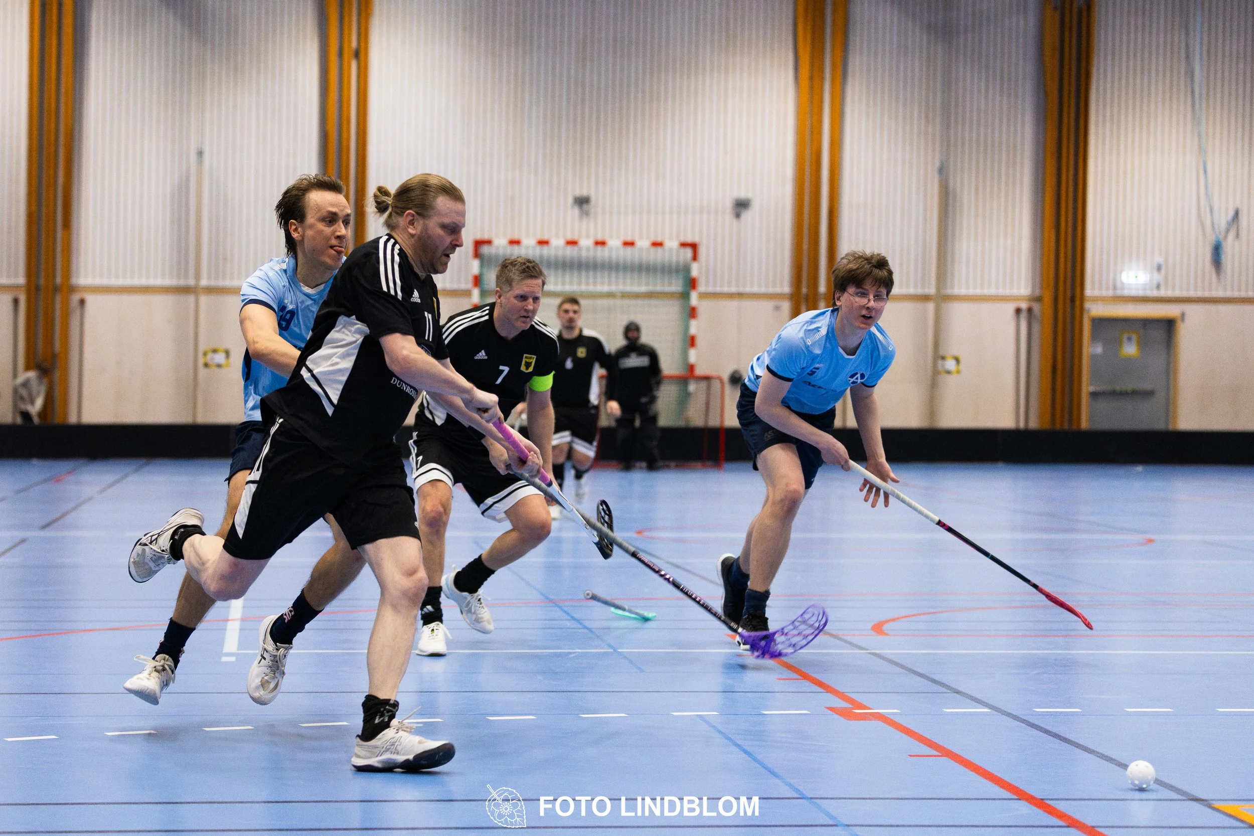 A picture of men playing floorball in Ingarö IF and Älvsjö AIK IBF team gear