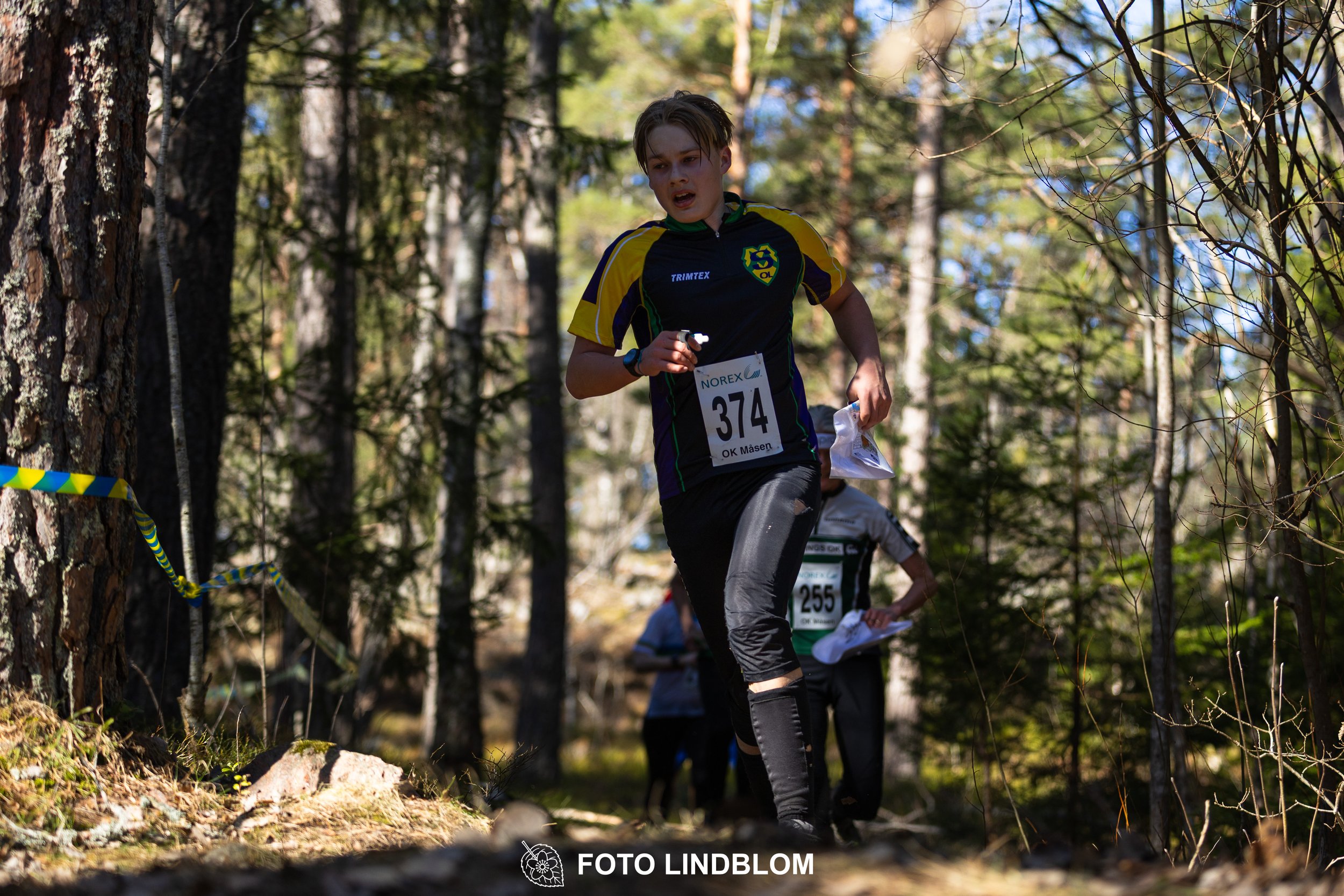 Forest relay orienteering at Måsenstafetten 2026, with teams competing in an endurance event, documented by Foto Lindblom.