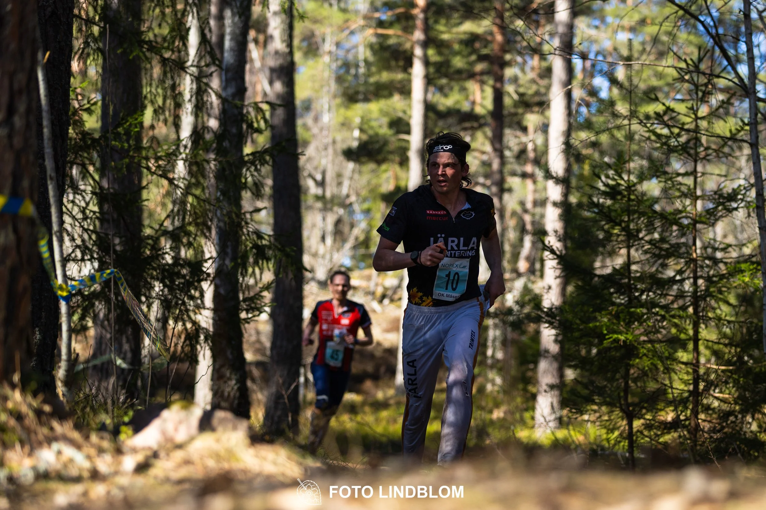 An image from the orienteering relay Måsenstafetten 2026, showing athletes in forest terrain, shot by Foto Lindblom.