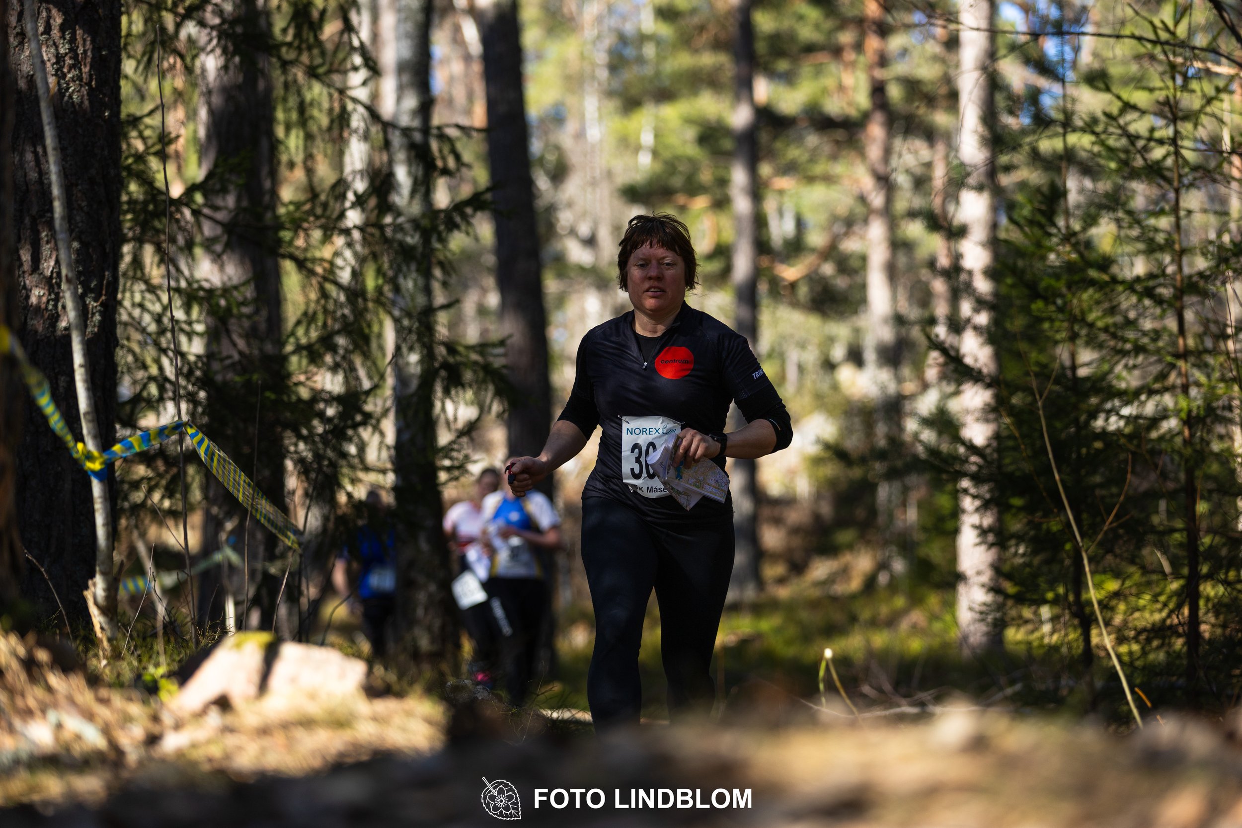 An image from the orienteering relay Måsenstafetten 2026, showing athletes in forest terrain, shot by Foto Lindblom.
