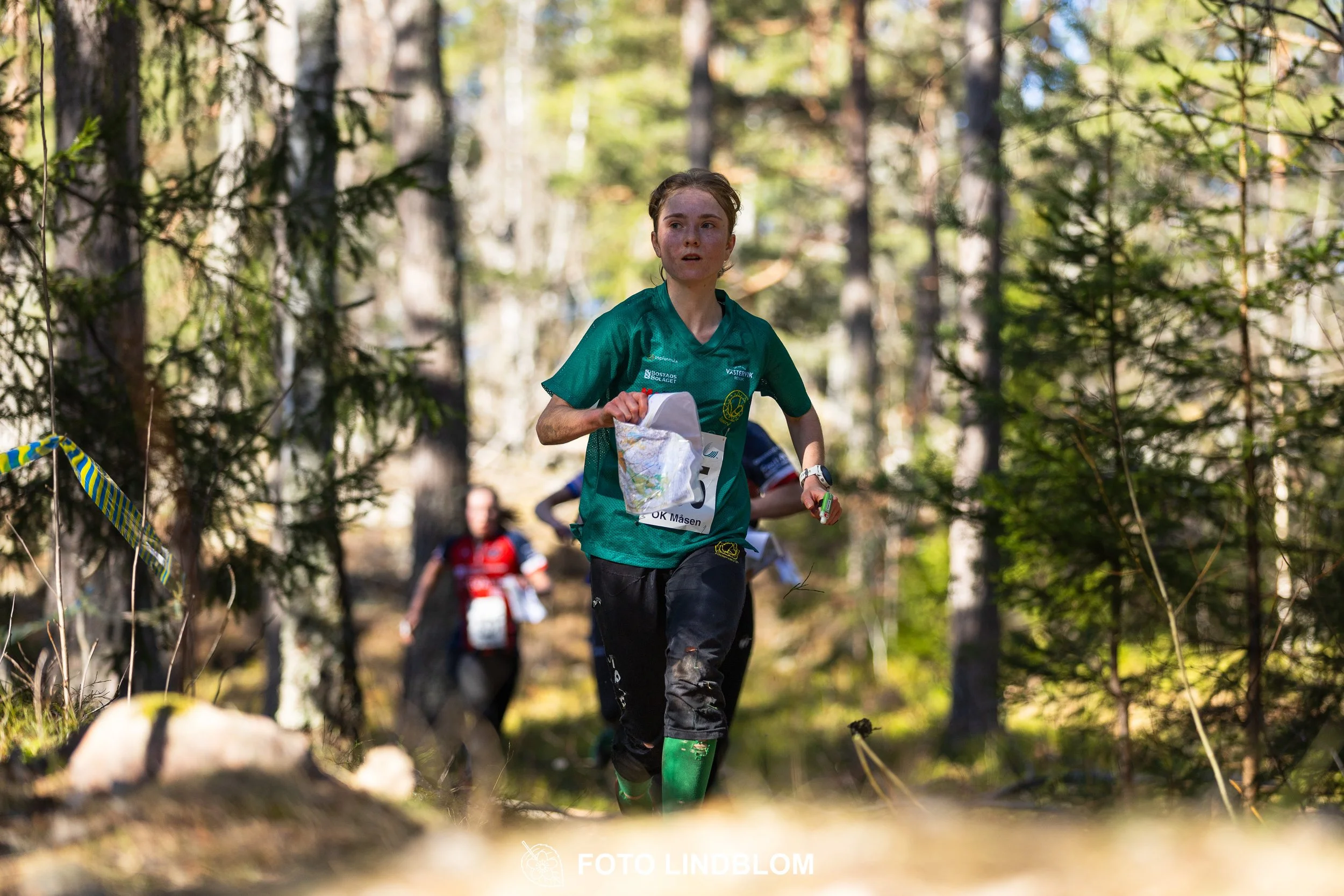 Photo of competitors during the Måsenstafetten 2026 team relay, showing Tuva Östangård, taken in a wooded landscape by Foto Lindblom.