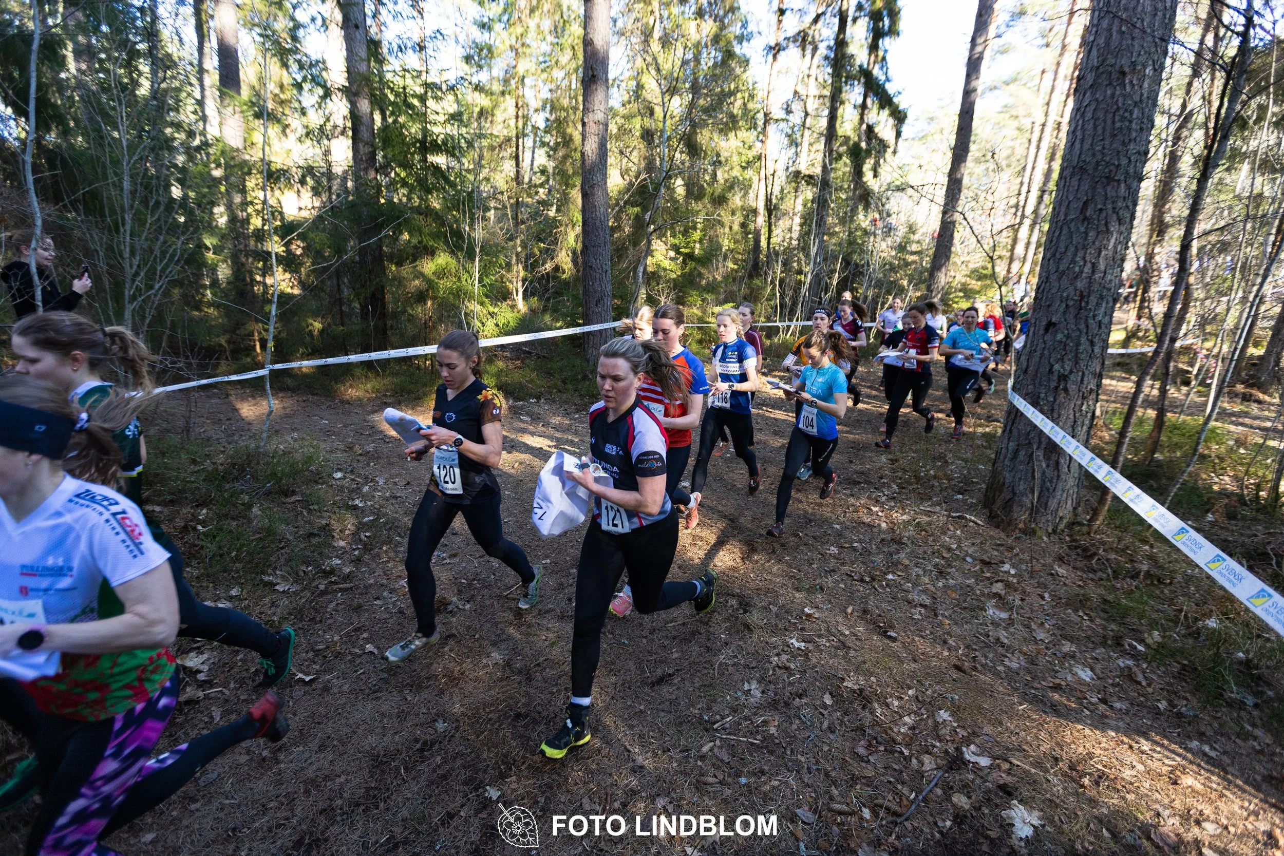 An image from the orienteering relay Måsenstafetten 2026, showing athletes in forest terrain, shot by Foto Lindblom.