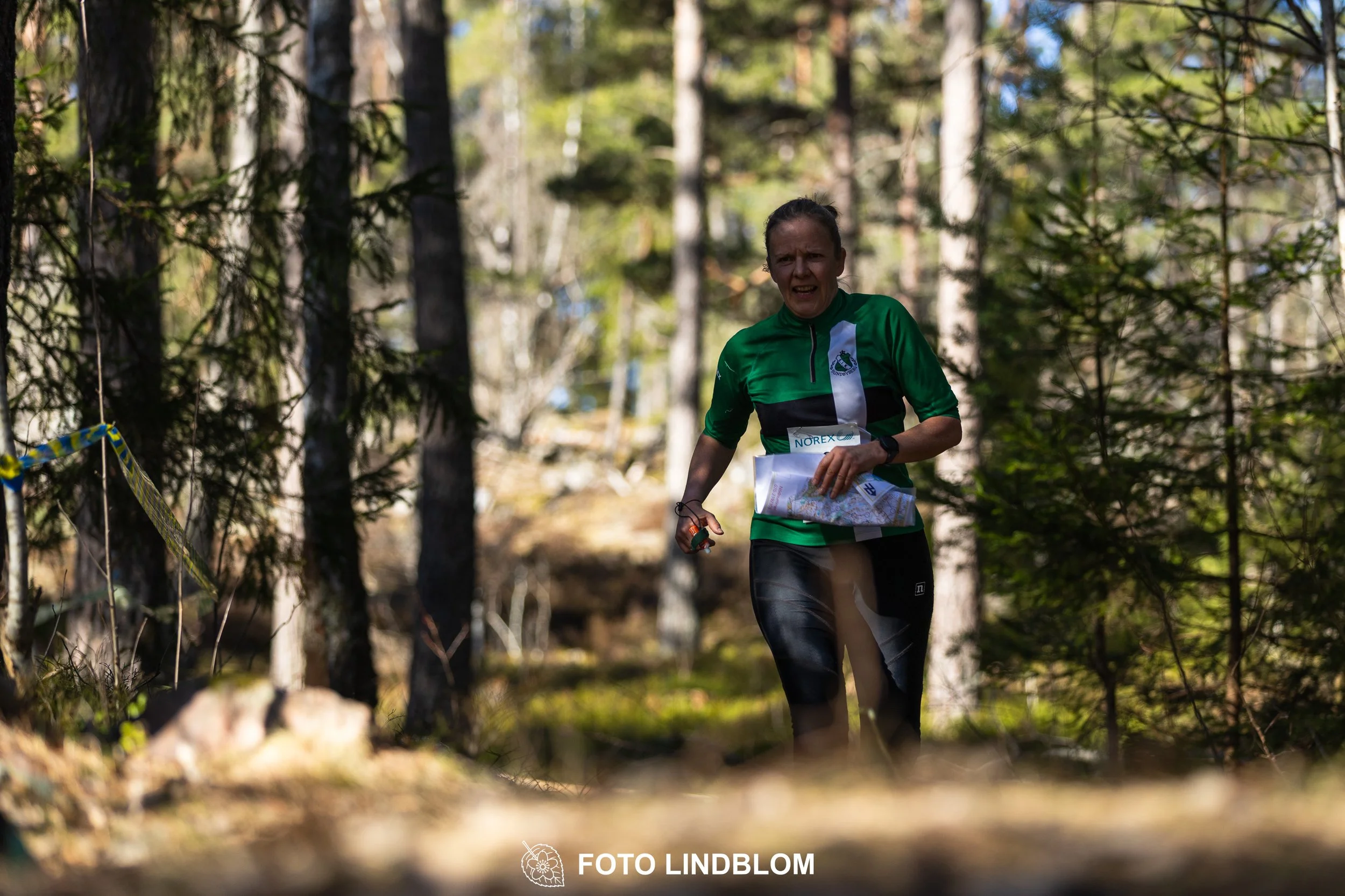 Swedish orienteering relay event Måsenstafetten 2026, with teams racing through forest terrain, captured by Foto Lindblom.