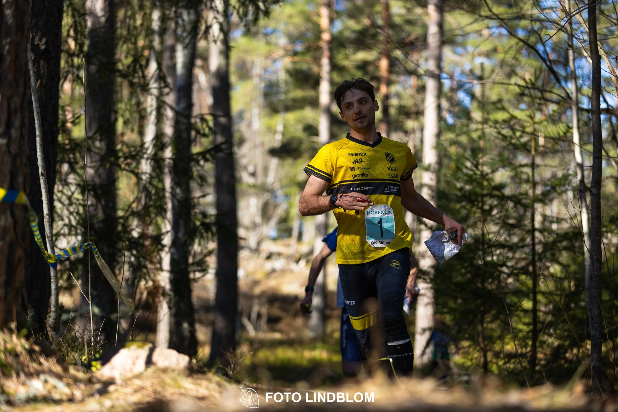 Orienteering relay race at Måsenstafetten 2026, featuring club teams navigating with map and compass, captured by Foto Lindblom.