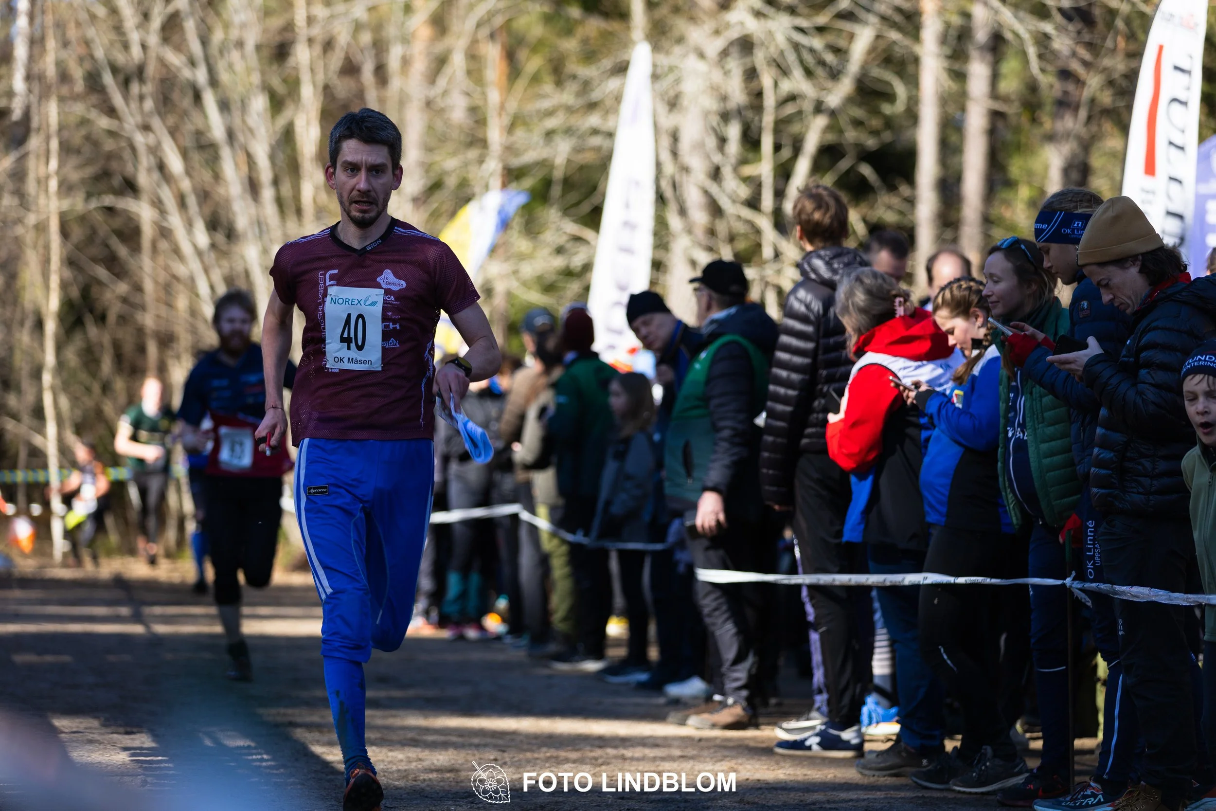 Photo of competitors during the Måsenstafetten 2026 team relay, taken in a wooded landscape by Foto Lindblom.