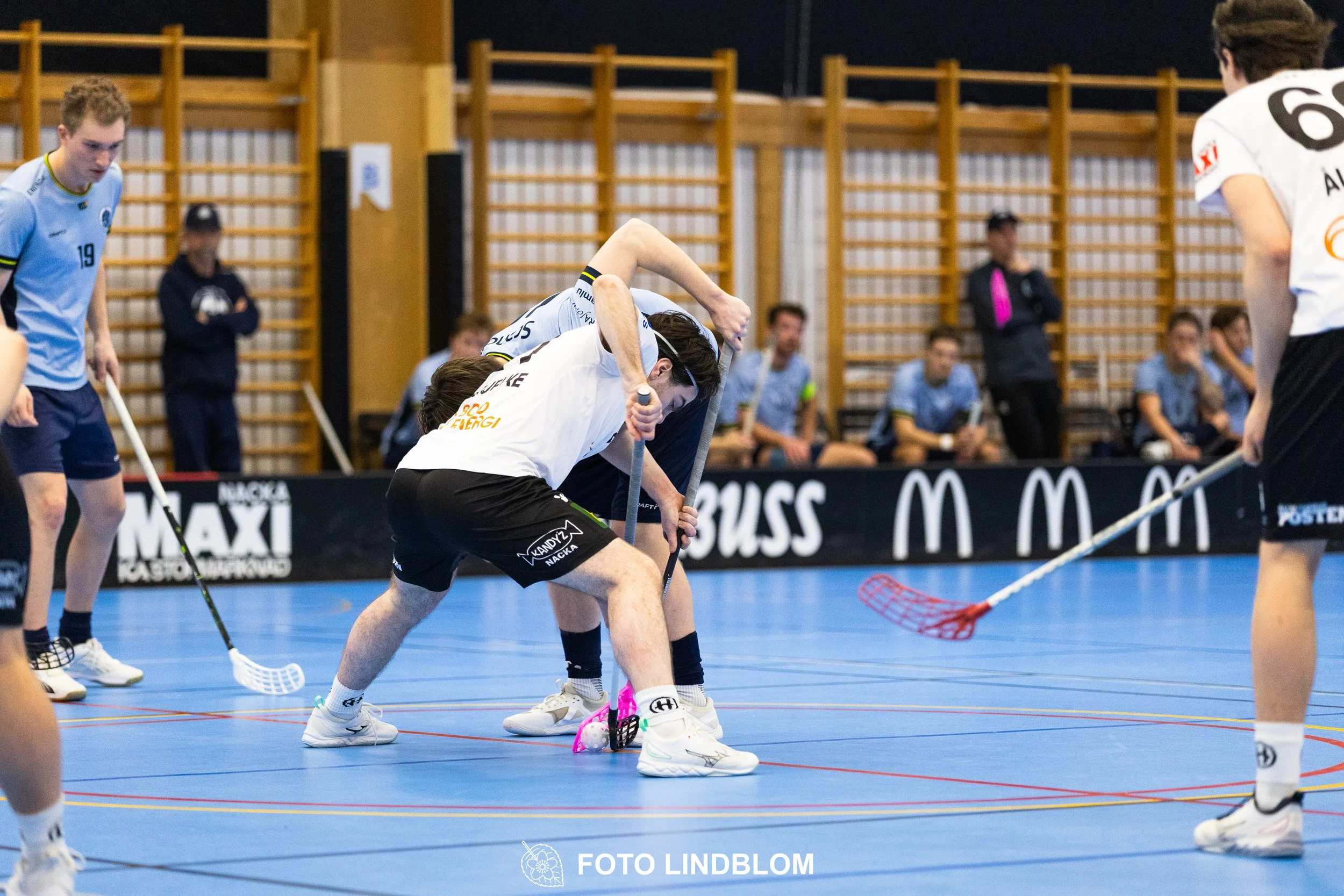 A picture of men playing floorball in Nacka IBK and FBC Sollentuna team gear