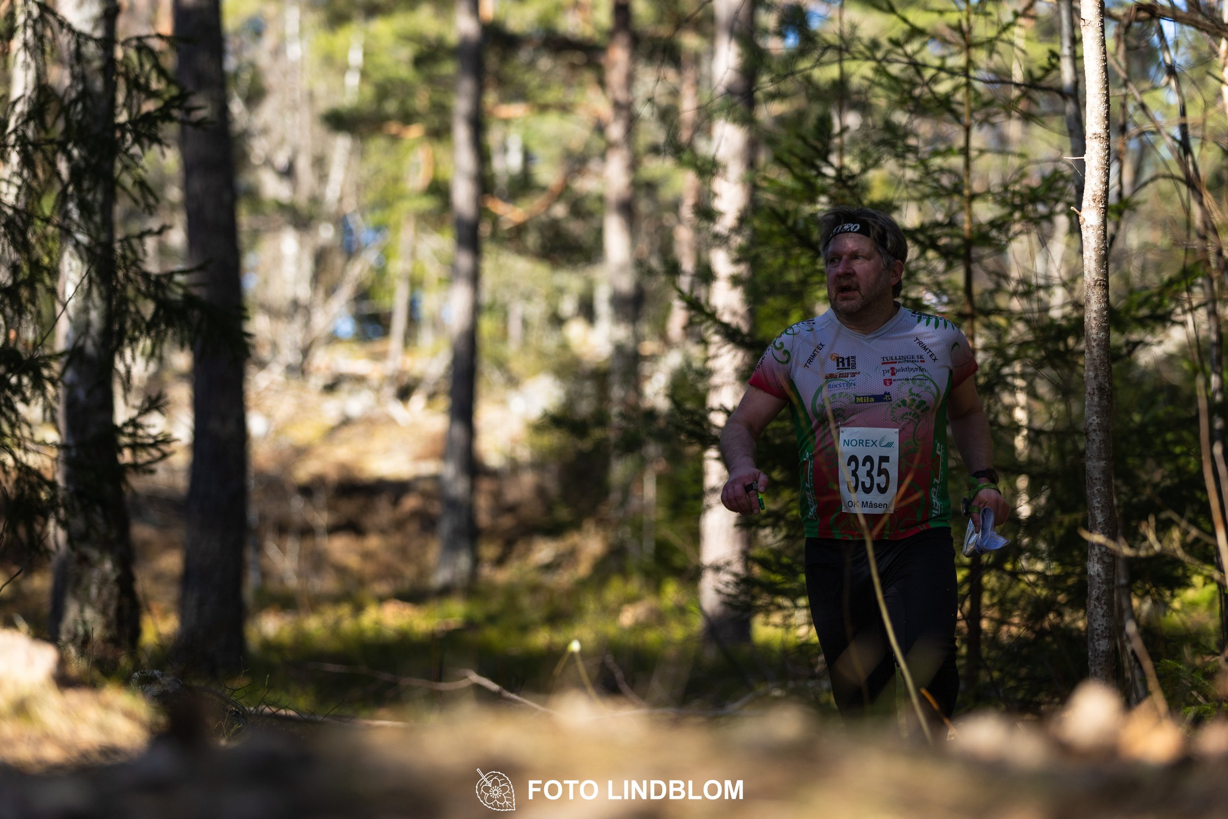 Swedish orienteering relay event Måsenstafetten 2026, with teams racing through forest terrain, captured by Foto Lindblom.