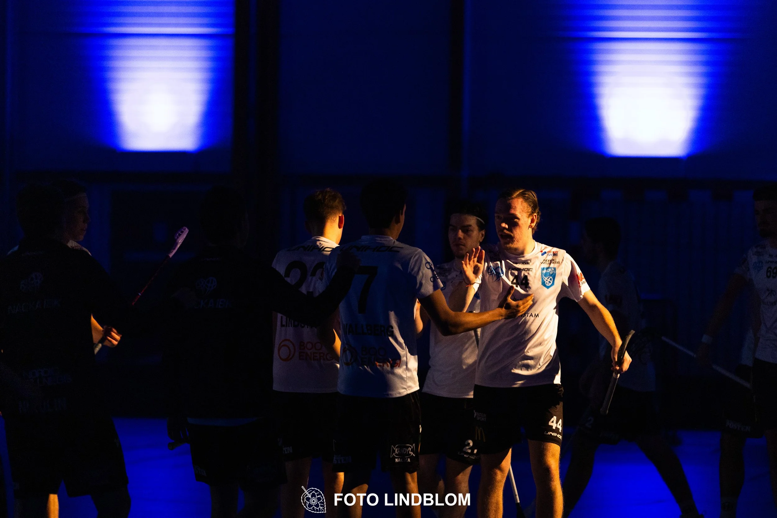 A picture of men playing floorball in Nacka IBK and FBC Sollentuna team gear