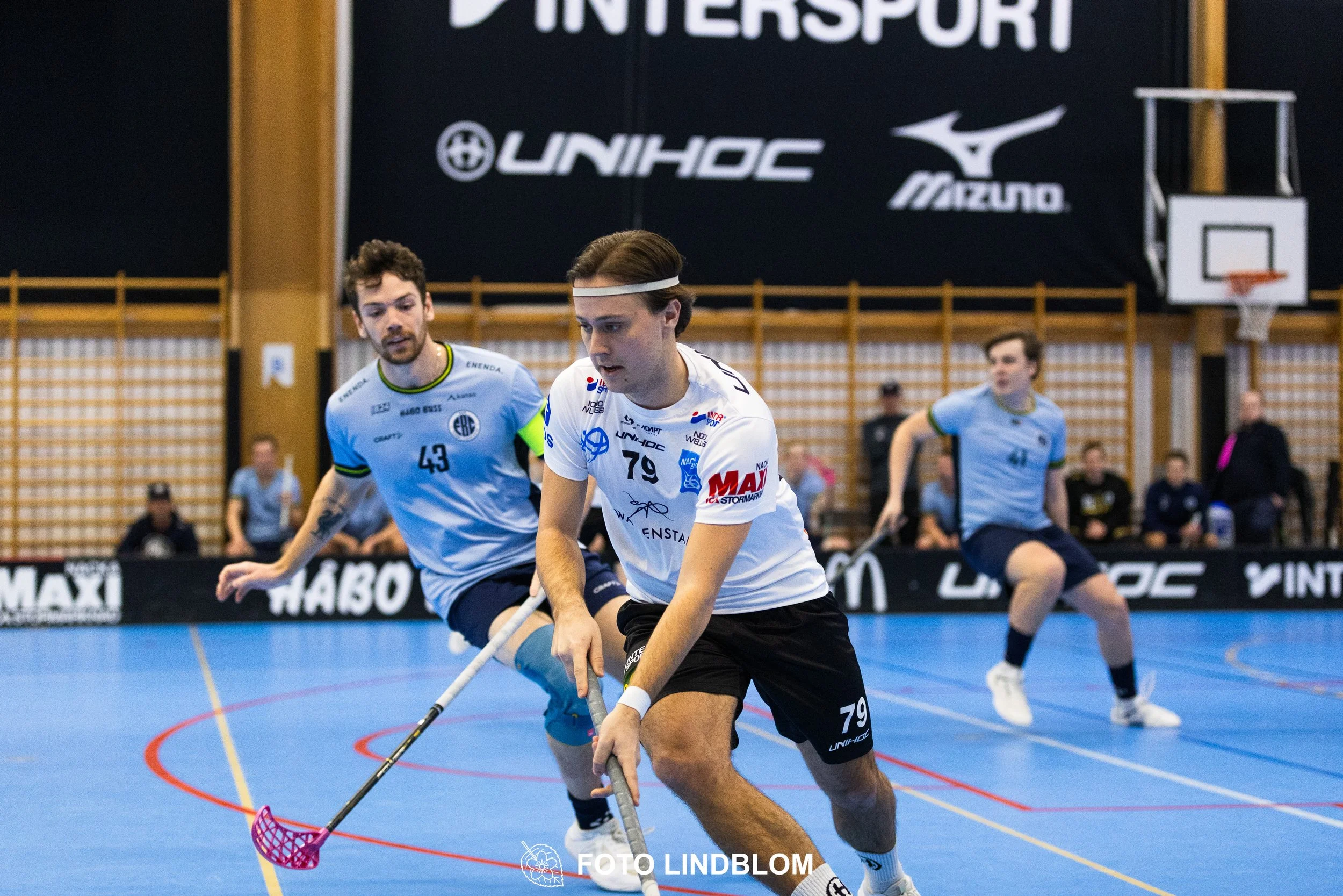 A picture of men playing floorball in Nacka IBK and FBC Sollentuna team gear