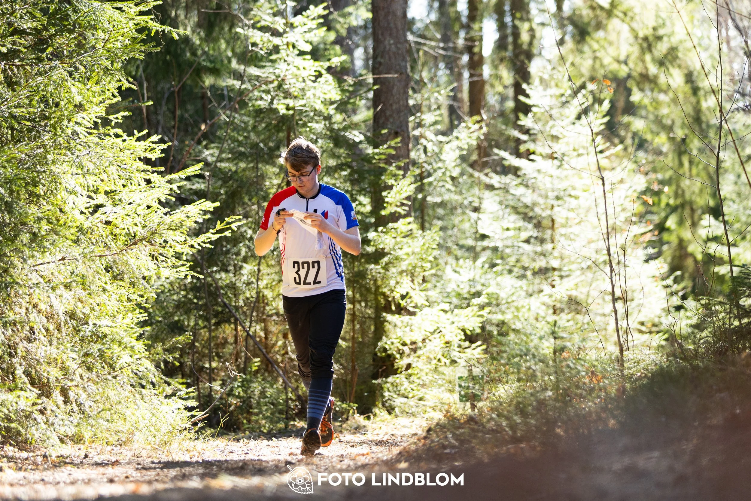 A photo from the 2026 Nyköpingsorienteringen orienteering event in a Swedish forest, captured by Foto Lindblom.
