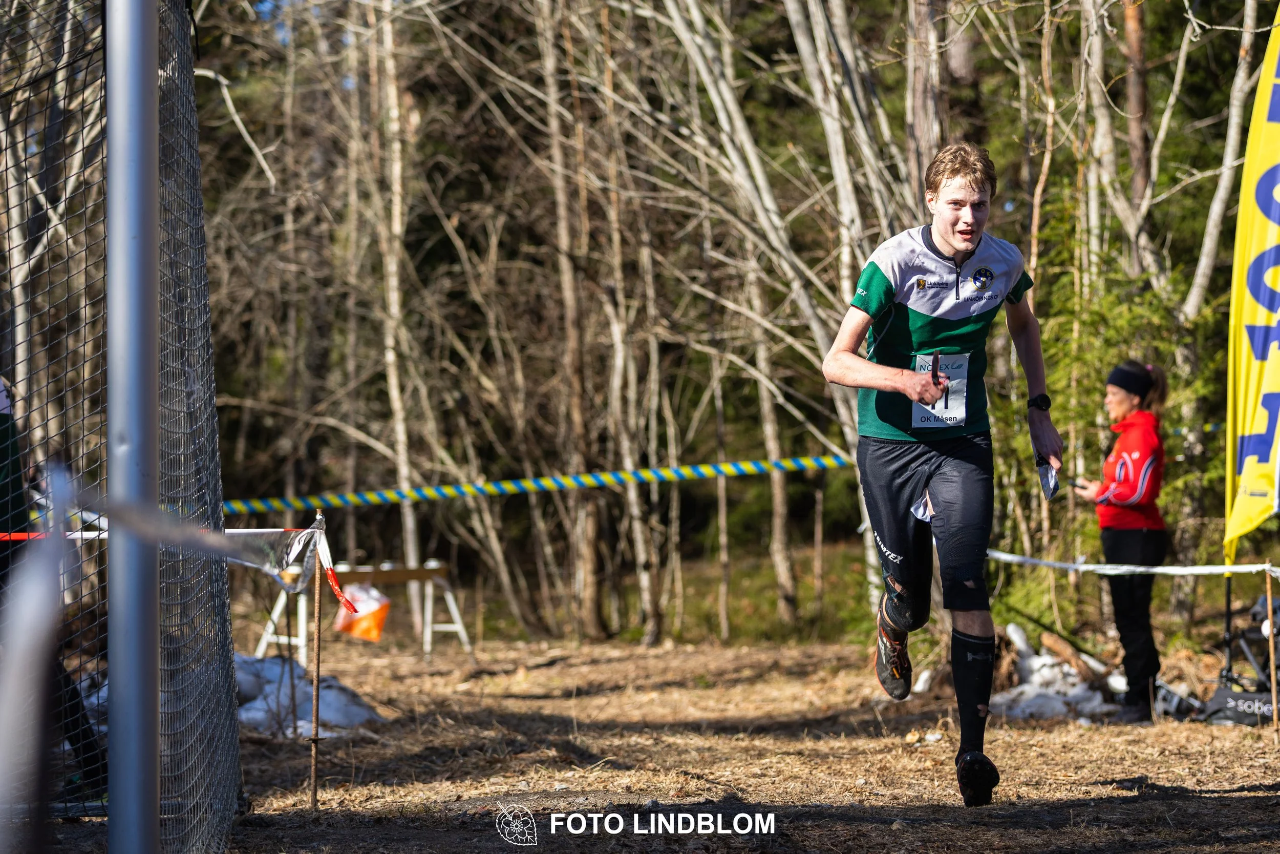 Swedish orienteering relay event Måsenstafetten 2026, with teams racing through forest terrain, captured by Foto Lindblom.