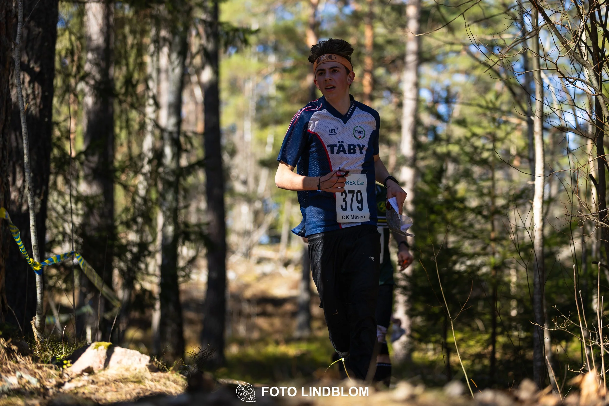 Forest relay orienteering at Måsenstafetten 2026, with teams competing in an endurance event, documented by Foto Lindblom.